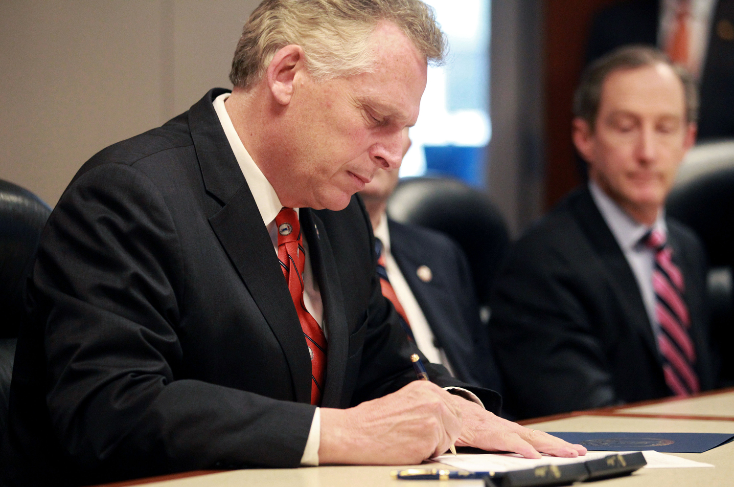 Virginia Governor Terry McAuliffe signs SB260, mental-health-reform legislation, at the University of Virginia Medical Center in Charlottesville, Va., on April 28, 2014 (Ryan M. Kelly—AP)