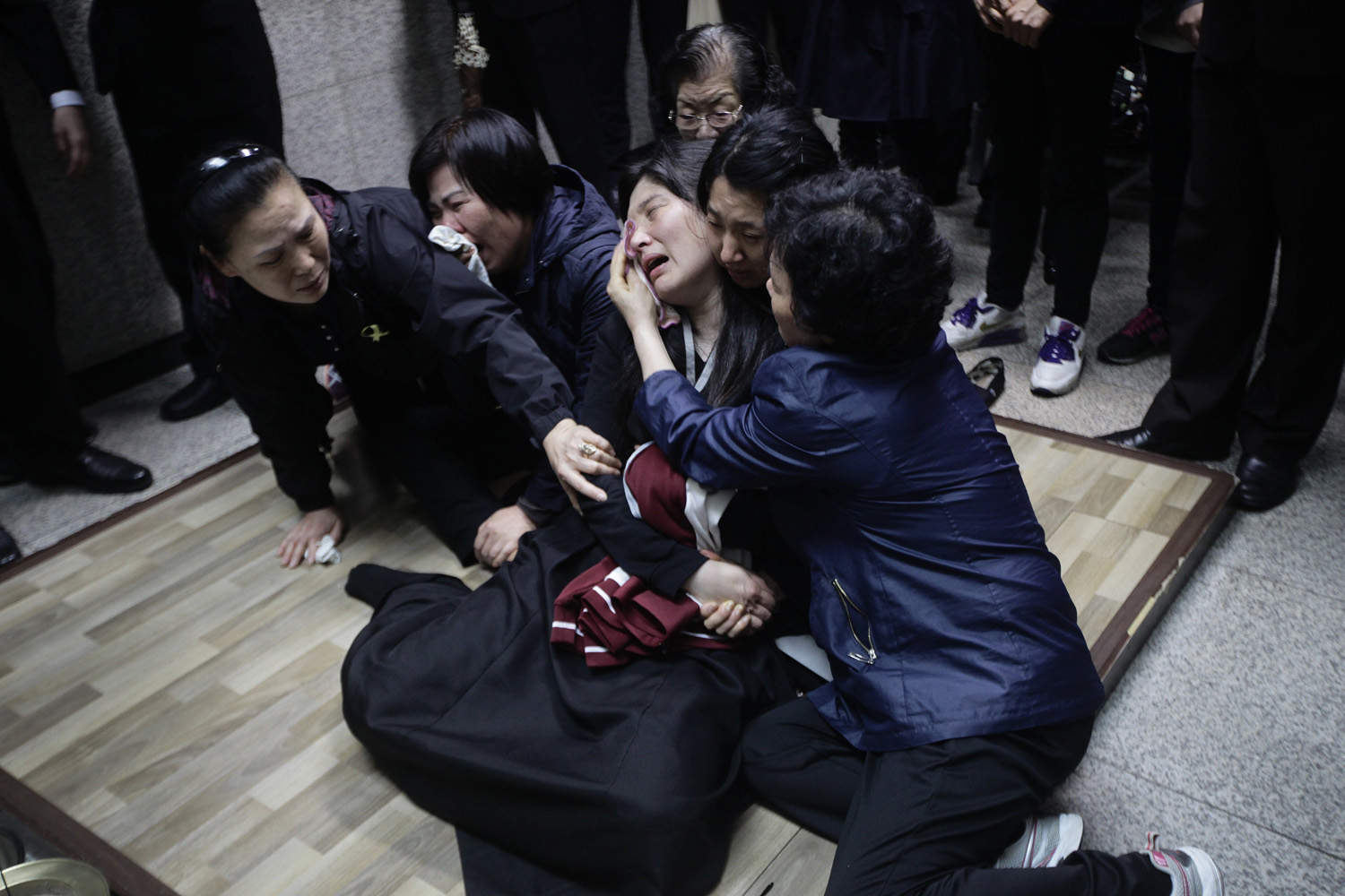 Eom Ji-young, center, mother of Park Yae-ji, a 16-year-old victim of the sunken Sewol ferry accident, collapses in grief as her daughter's remains enter the kiln at a crematorium in Suwon, South Korea.