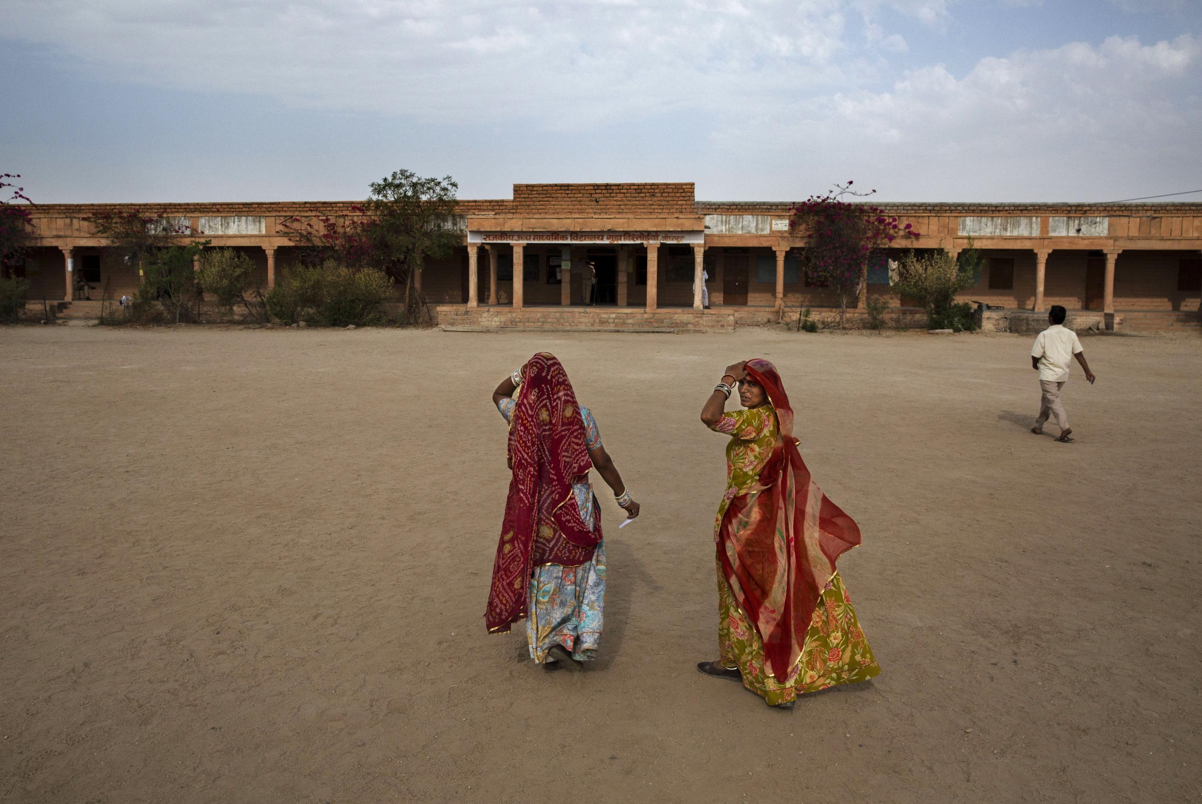 Indian women arrive to vote at a polling station on April 17, 2014 in the Jodhpur District in the desert state of Rajasthan.