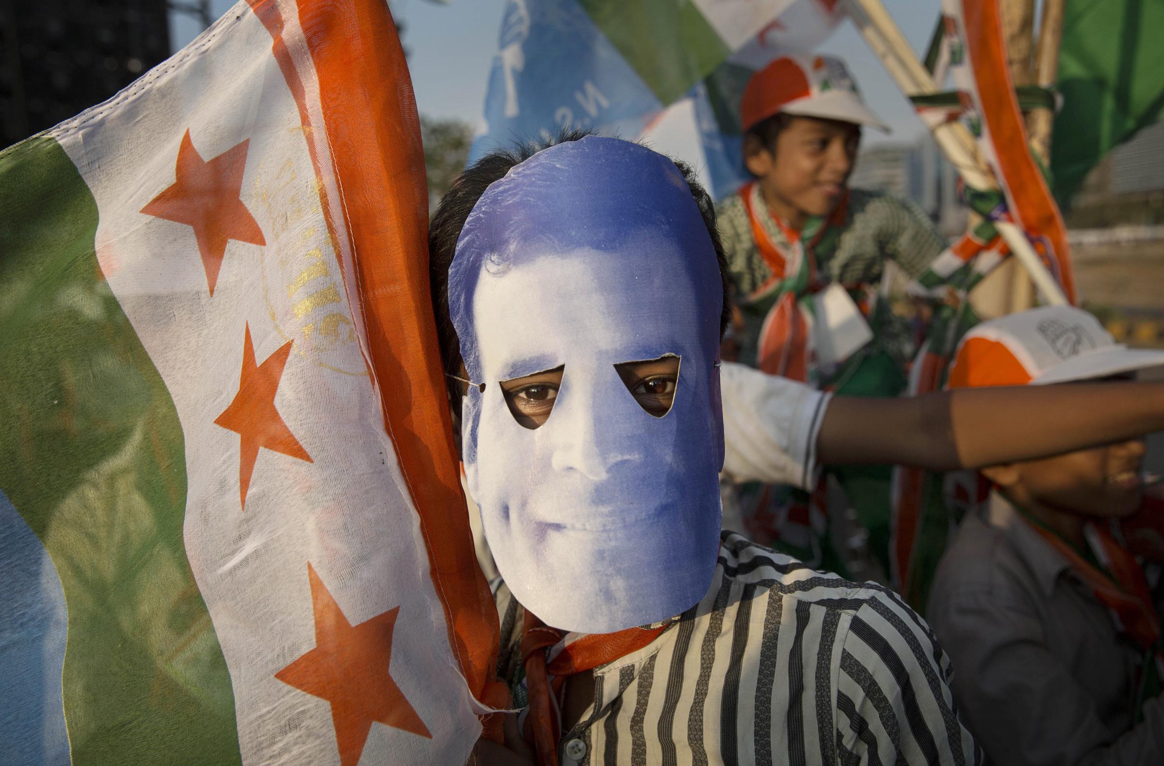 A supporter of India's ruling Congress Party wears a mask of leader Rahul Gandhi during a rally on April 20, 2014 in Mumbai.