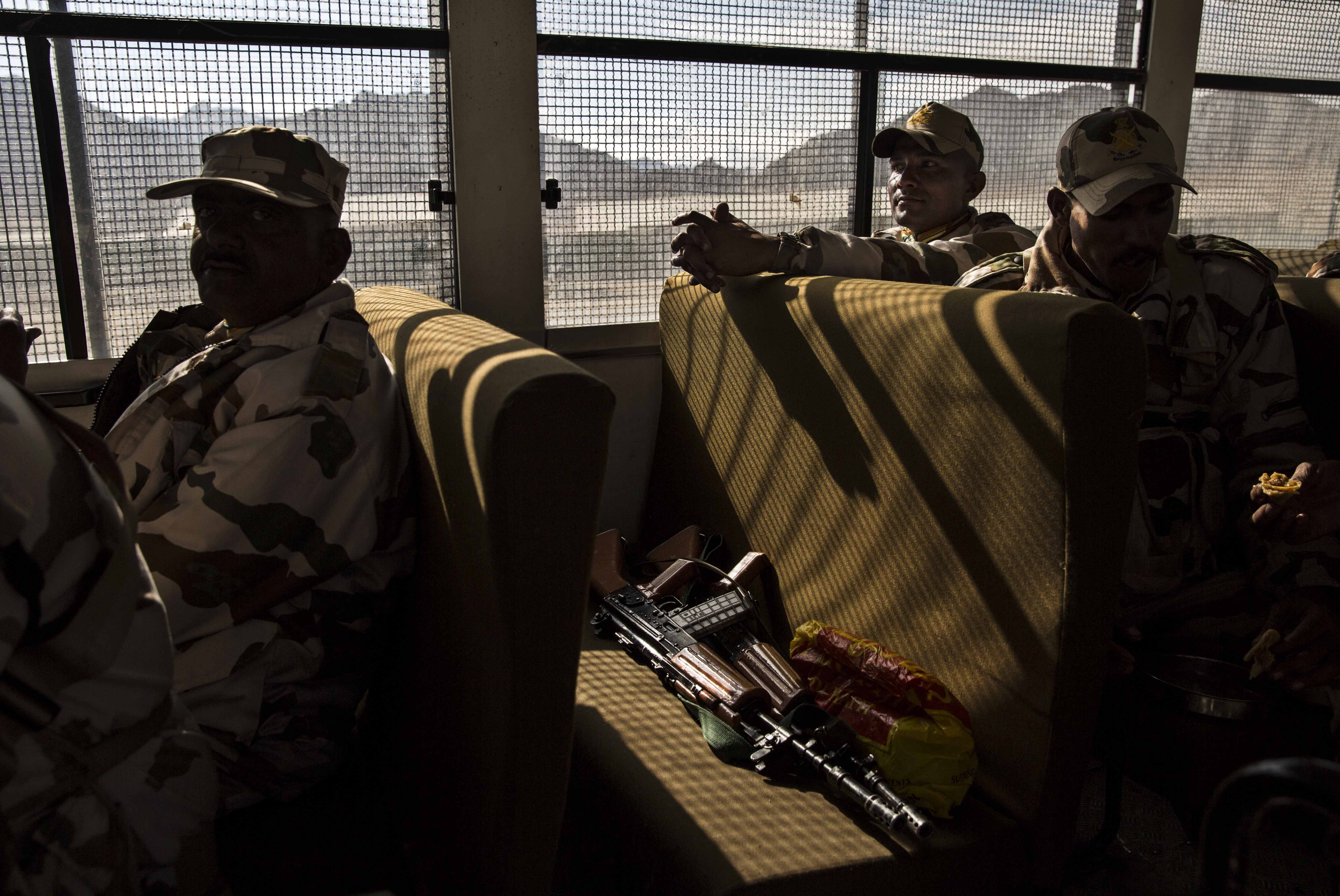 Security force soldiers on election duty sit in a bus as they leave a central collection point to head for a polling station, on May 6, 2014 in Leh, Ladakh.