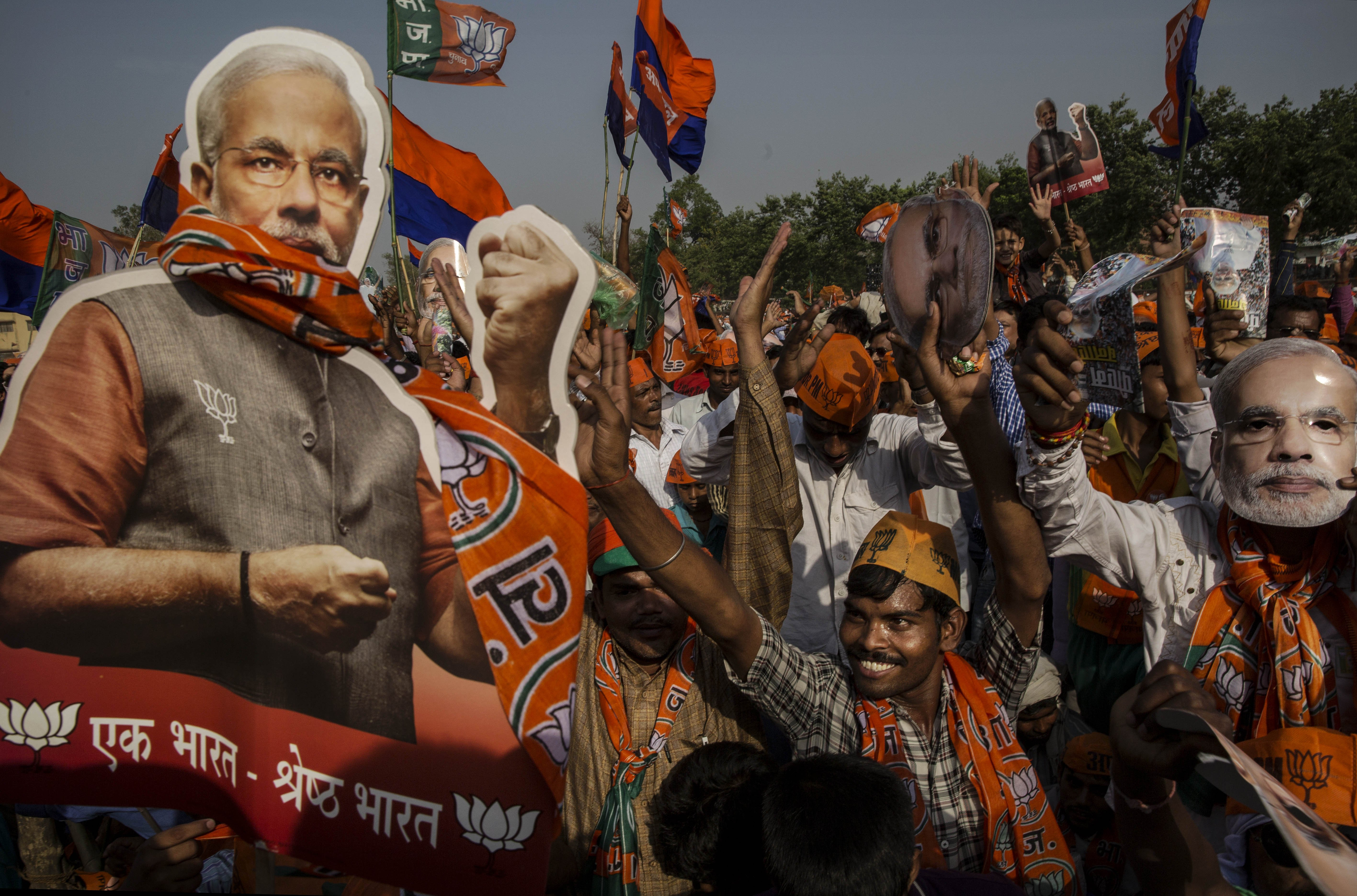 Supporters of BJP leader Narendra Modi cheer during his speech at a rally by him on May 8, 2014 in Rohaniya, near Varanasi.