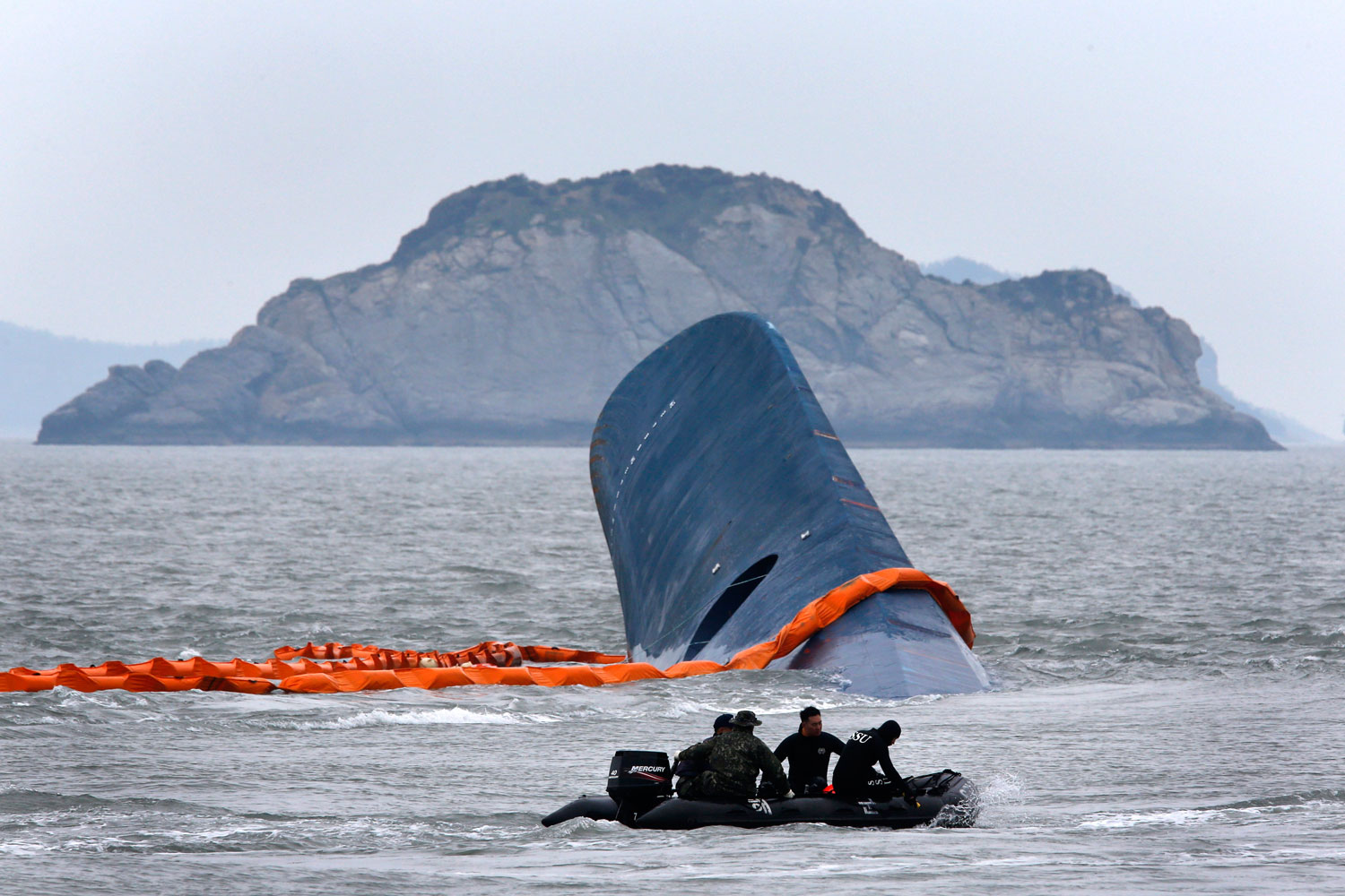 A dinghy involved in salvage operations passes near the upturned South Korean ferry <i>Sewol</i> in the sea off Jindo, South Korea, on April 17, 2014 (Kim Kyung-Hoon—Reuters)