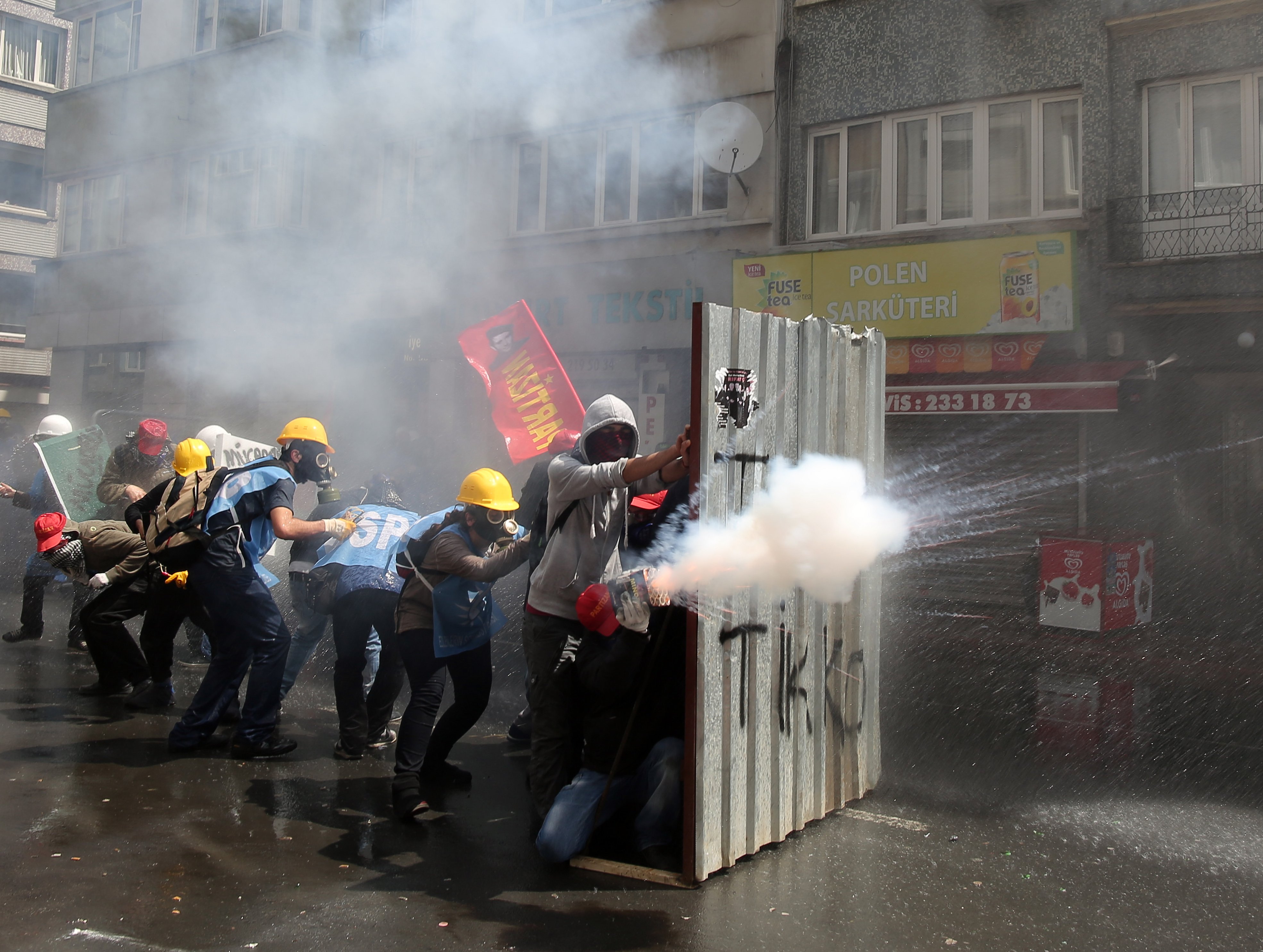 Protesters fire back as riot police use water cannons and teargas to disperse thousands of people trying to reach the city's main Taksim Square to celebrate May Day in Istanbul, May 1, 2014.