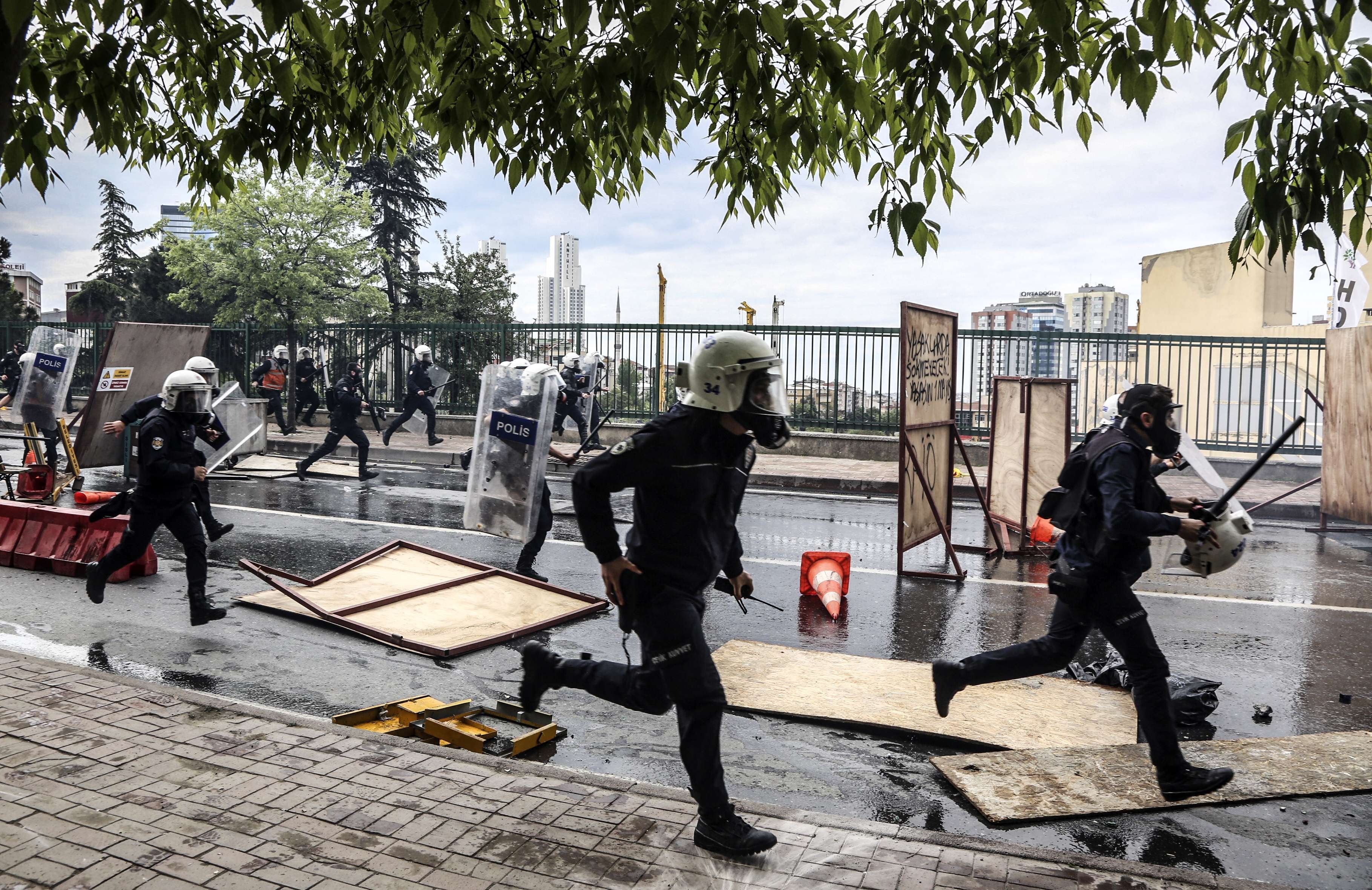 Turkish riot policemen run after protesters to disperse a May Day rally near Taksim Square in Istanbul on May 1, 2014.