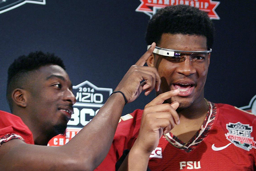 Florida State wide receiver Kenny Shaw, left, helps quarterback Jameis Winston don a pair of Google Glasses during the BCS Championship Game Media Day at the Newport Beach Marriott Hotel Spa in Newport Beach, Calif. on Jan. 4, 2014.