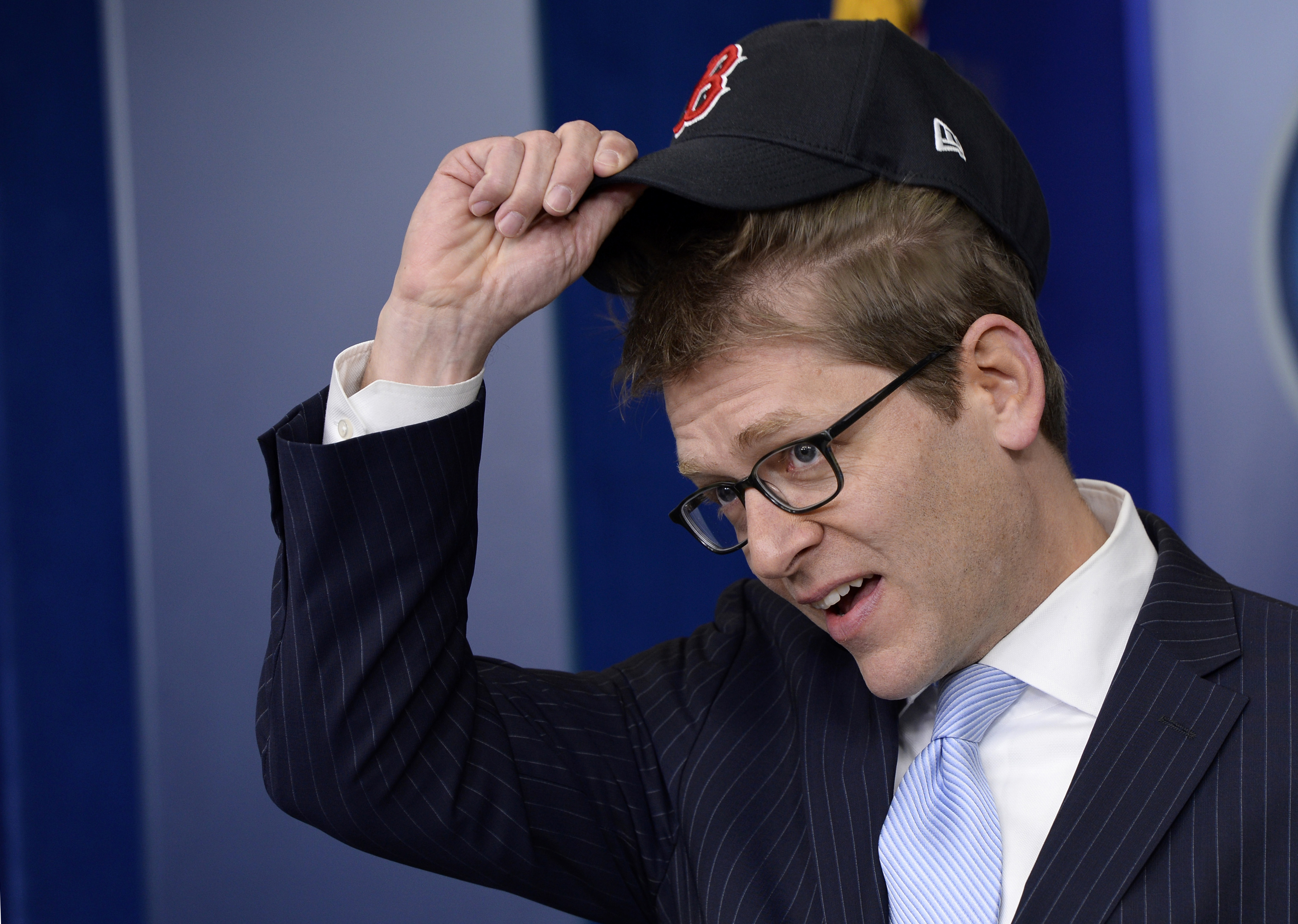 White House press secretary Jay Carney begins the daily briefing tipping his Boston Red Sox baseball cap at the White House on April 1, 2014 in Washington.