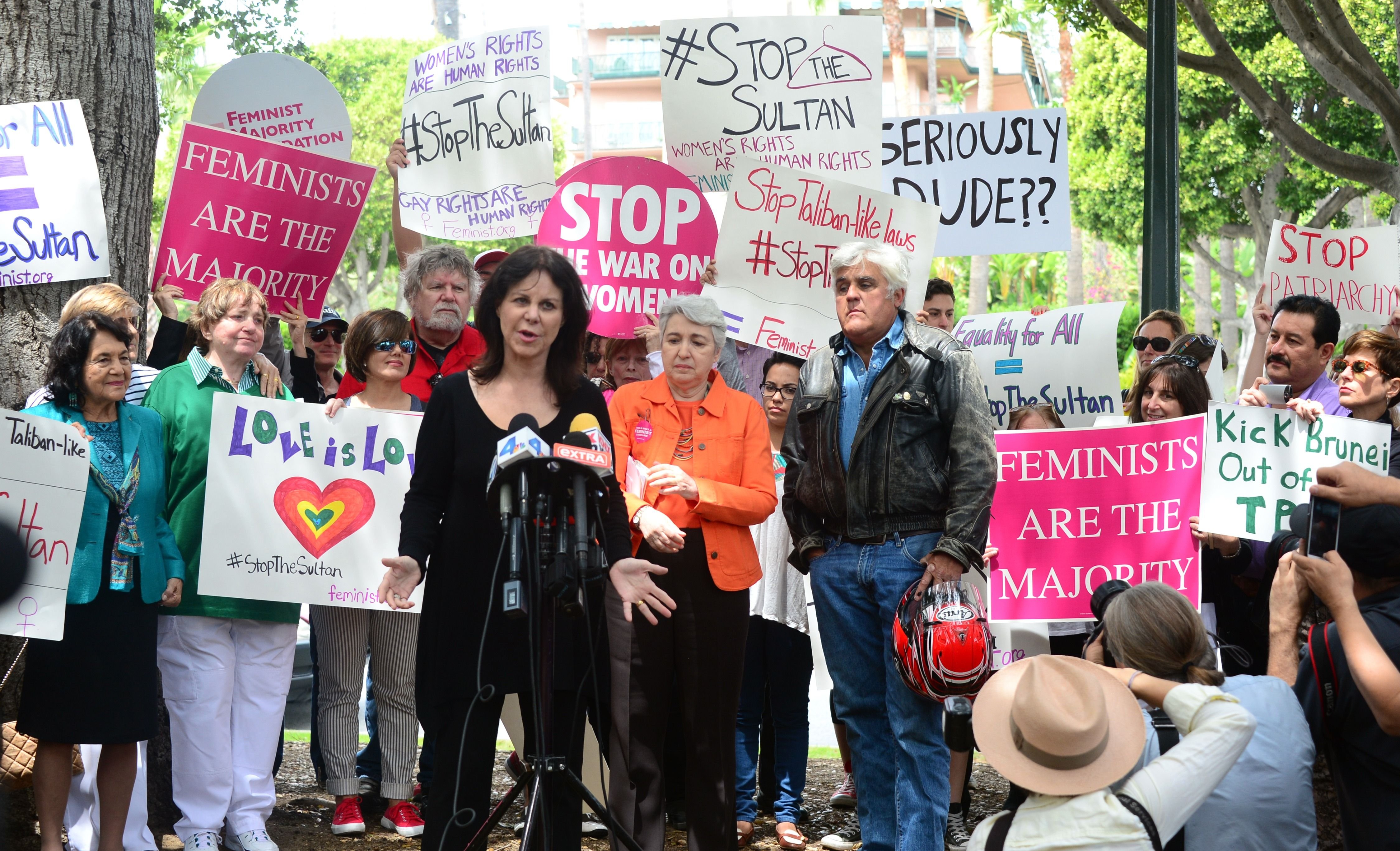 Jay Leno watches as his wife Mavis speaks to supporters of women's rights and LGBT groups at a protest across from the Beverly Hills Hotel, owned by the Sultan of Brunei, on May 5, 2014 in Beverly Hills, Calif.