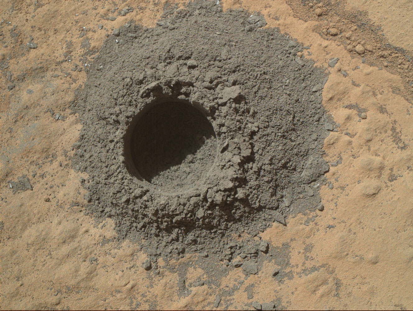 NASA's Mars Curiosity rover completed a shallow  mini drill  experiment on April 29, 2014, as part of its preliminary examination of a rock target called  Windjana.  The hole in this image is 0.63 inch (1.6 centimeters) in diameter and about 0.8 inch (2 centimeters) deep.