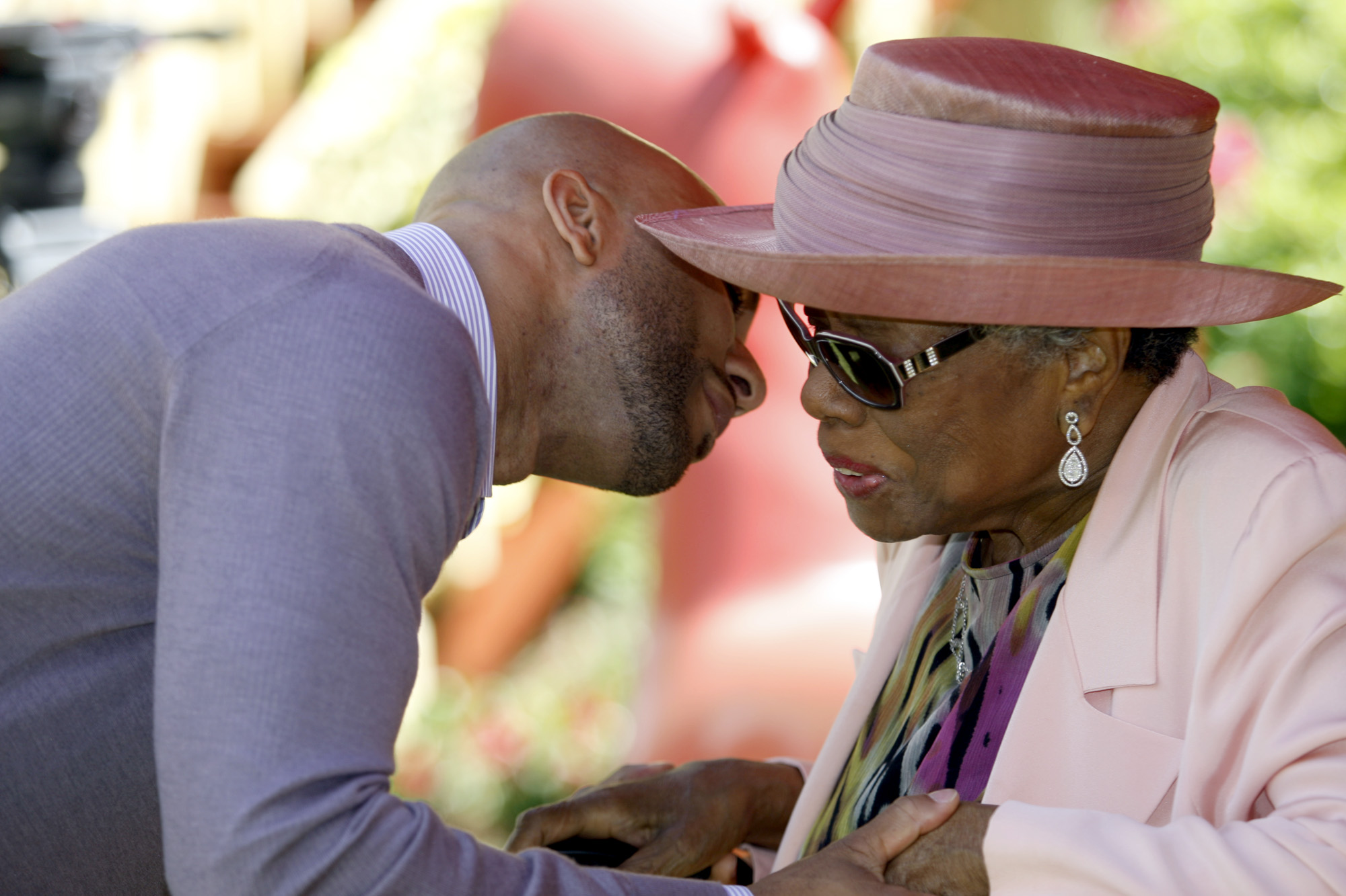 Common greets Maya Angelou at a garden party at Angelou's home in 2010.