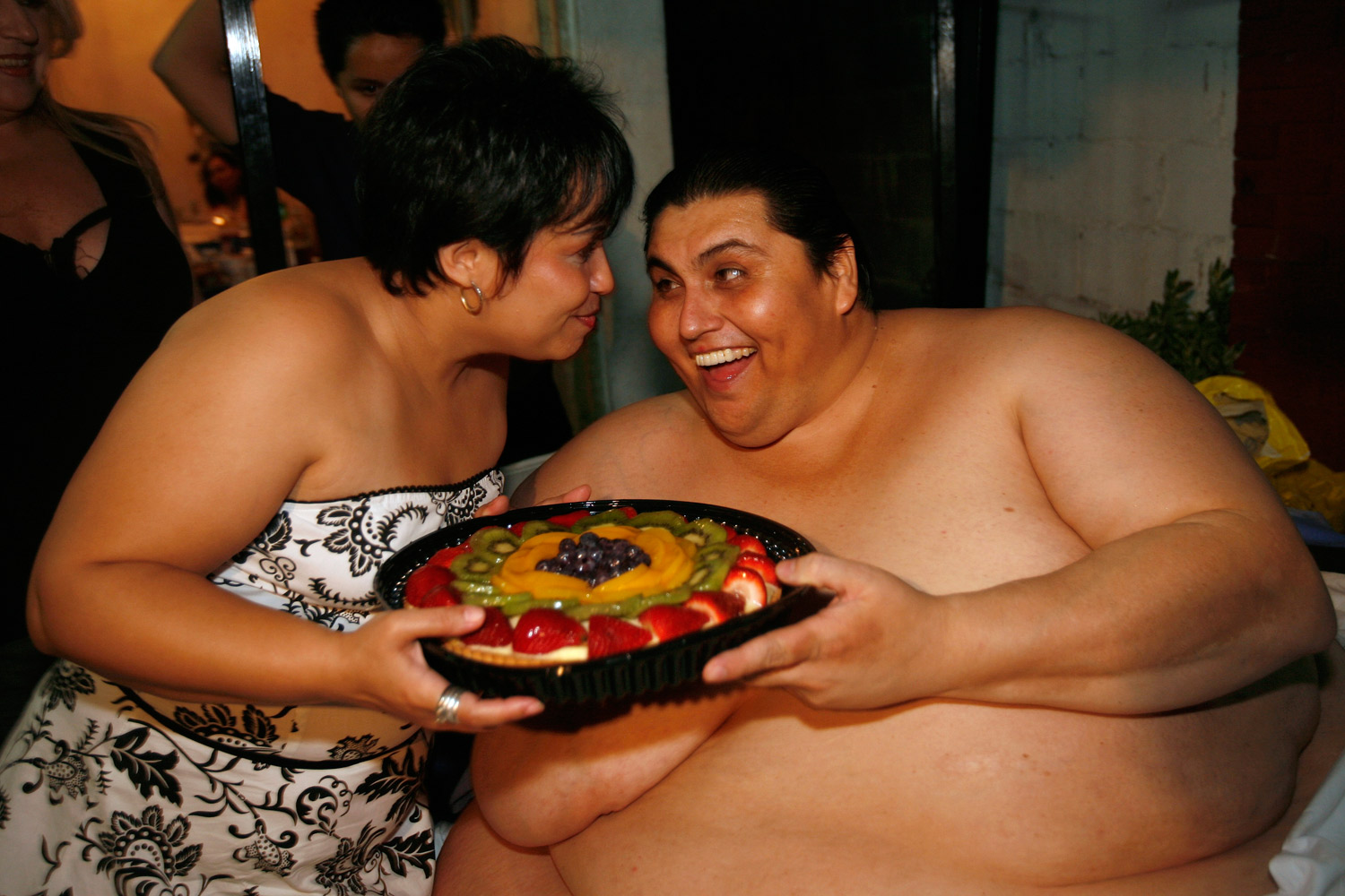 Manuel Uribe jokes as he holds a fruit cake with his girlfriend Claudia Solis outside his house in the suburb of San Nicolas de los Garza in the northern city of Monterrey, Mexico, June 11, 2008. (Tomas Bravo / Reuters)