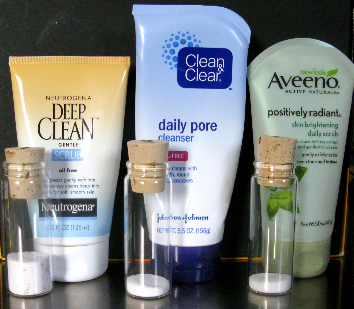 Vials of microbeads alongside products that use such small, plastic spheres.