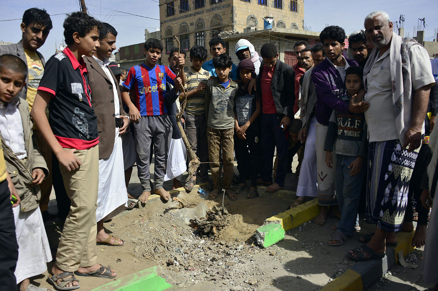 Yemenis gather at the site of a bomb explosion that targeted an army troop vehicle on its way to man a checkpoint on a street leading to two western embassies on May 9, 2014 in the capital Sanaa. (Mohammed Huwais—AFP/Getty Images)