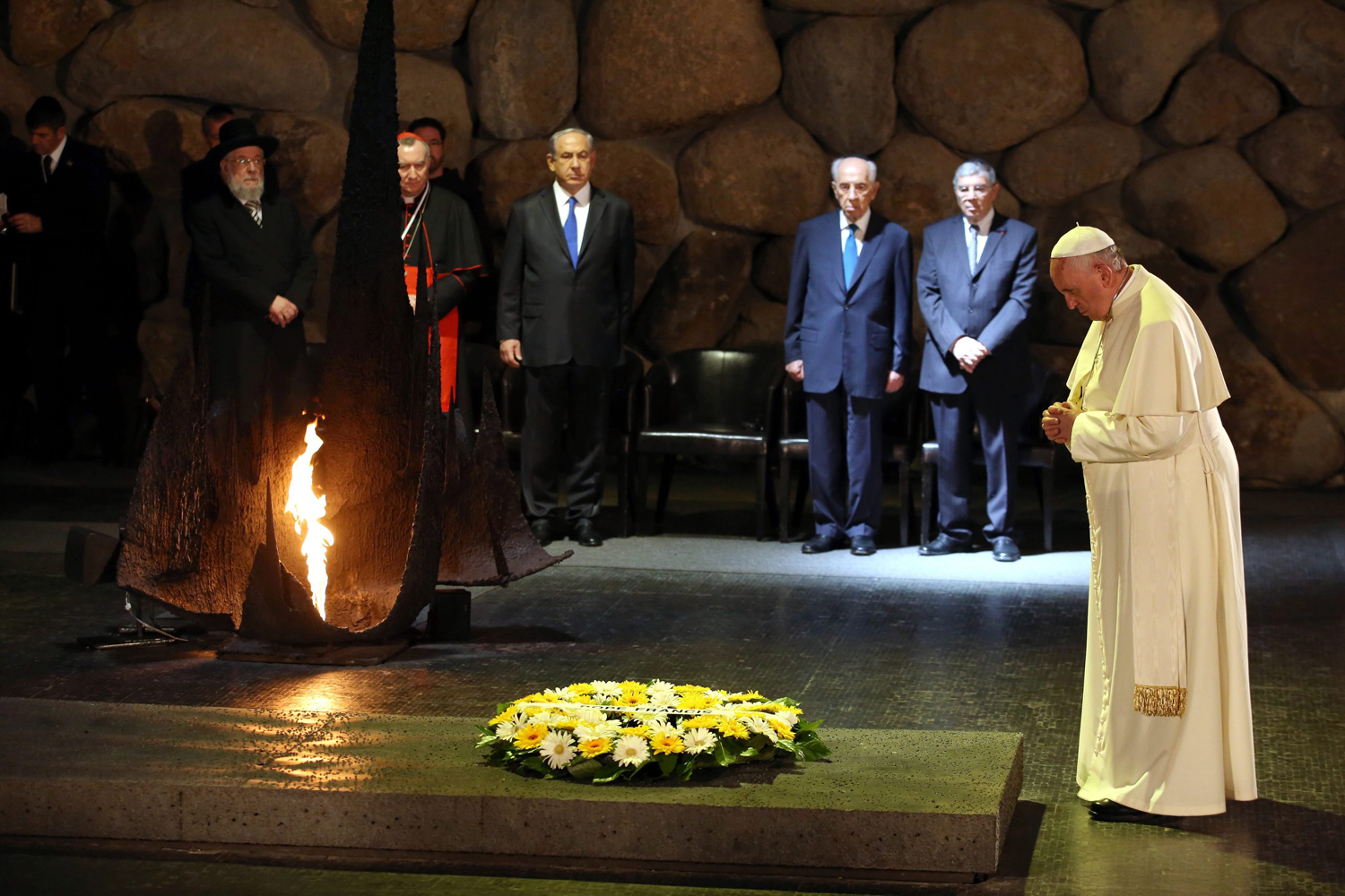 Pope Francis prays after laying a wreath as Israeli Prime Minister Benjamin Netanyahu and Israeli President Shimon Peres look on during a memorial ceremony in the Hall of Remembrances in the Yad Vashem Holocaust memorial in Jerusalem, May 26, 2014.