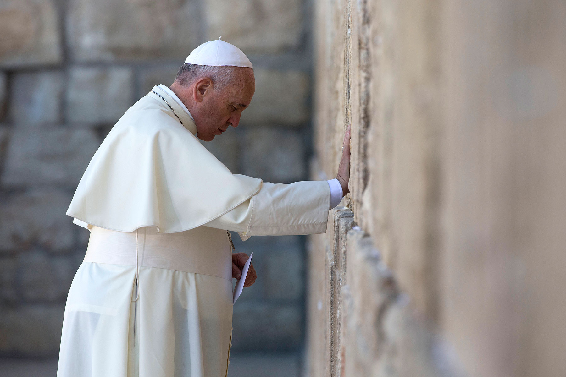 Pope Francis prays as he holds an envelope before placing it in one of the cracks between the stones of the Western Wall, the holiest place where Jews can pray, in Jerusalem on May 26, 2014 (Andrew Medichini—AP)