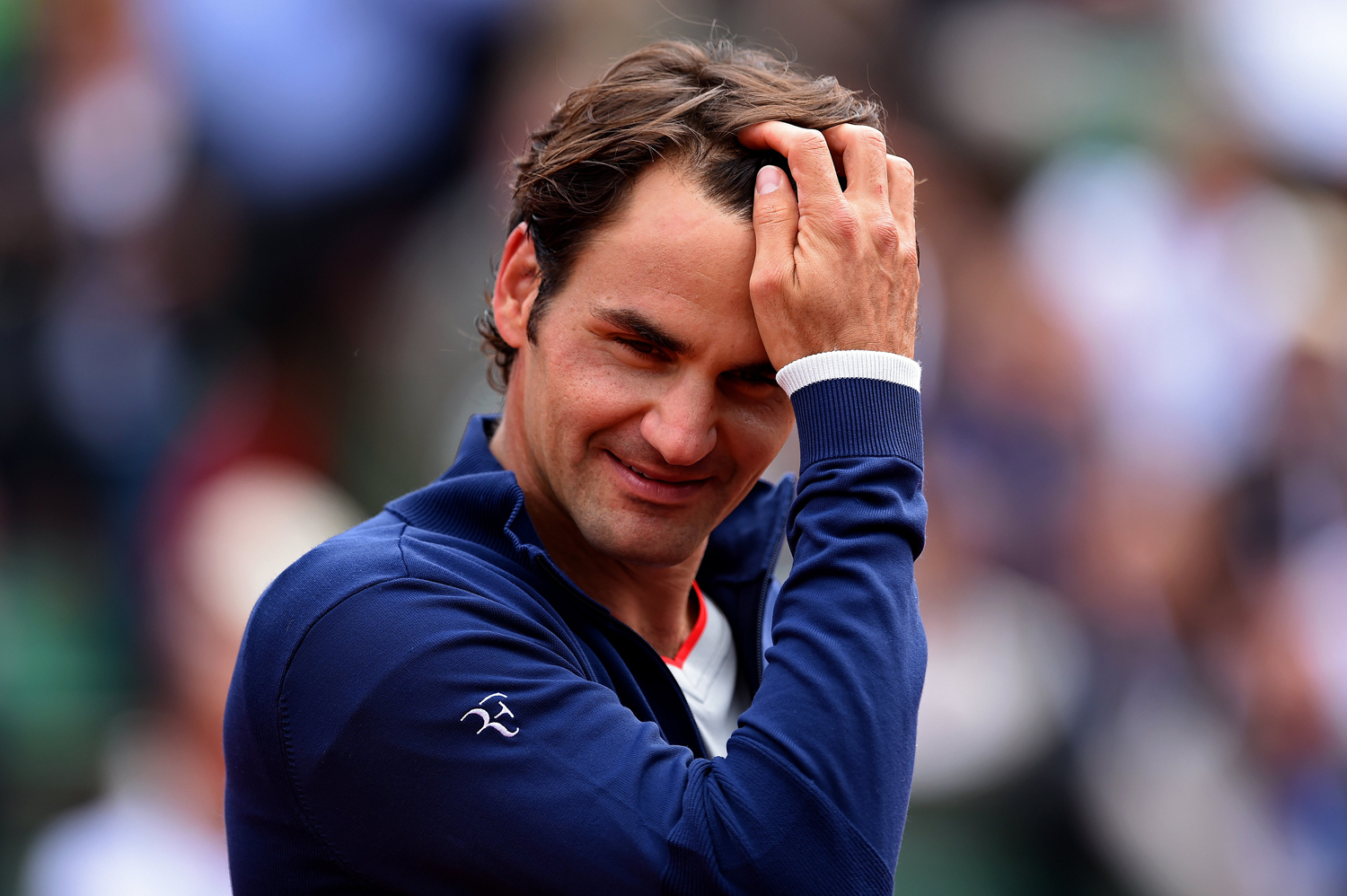 Roger Federer smiles following victory in his men's singles match against Lukas Lacko of Slovakia on day one of the French Open at Roland Garros on May 25, 2014 in Paris. (Matthias Hangst—Getty Images)