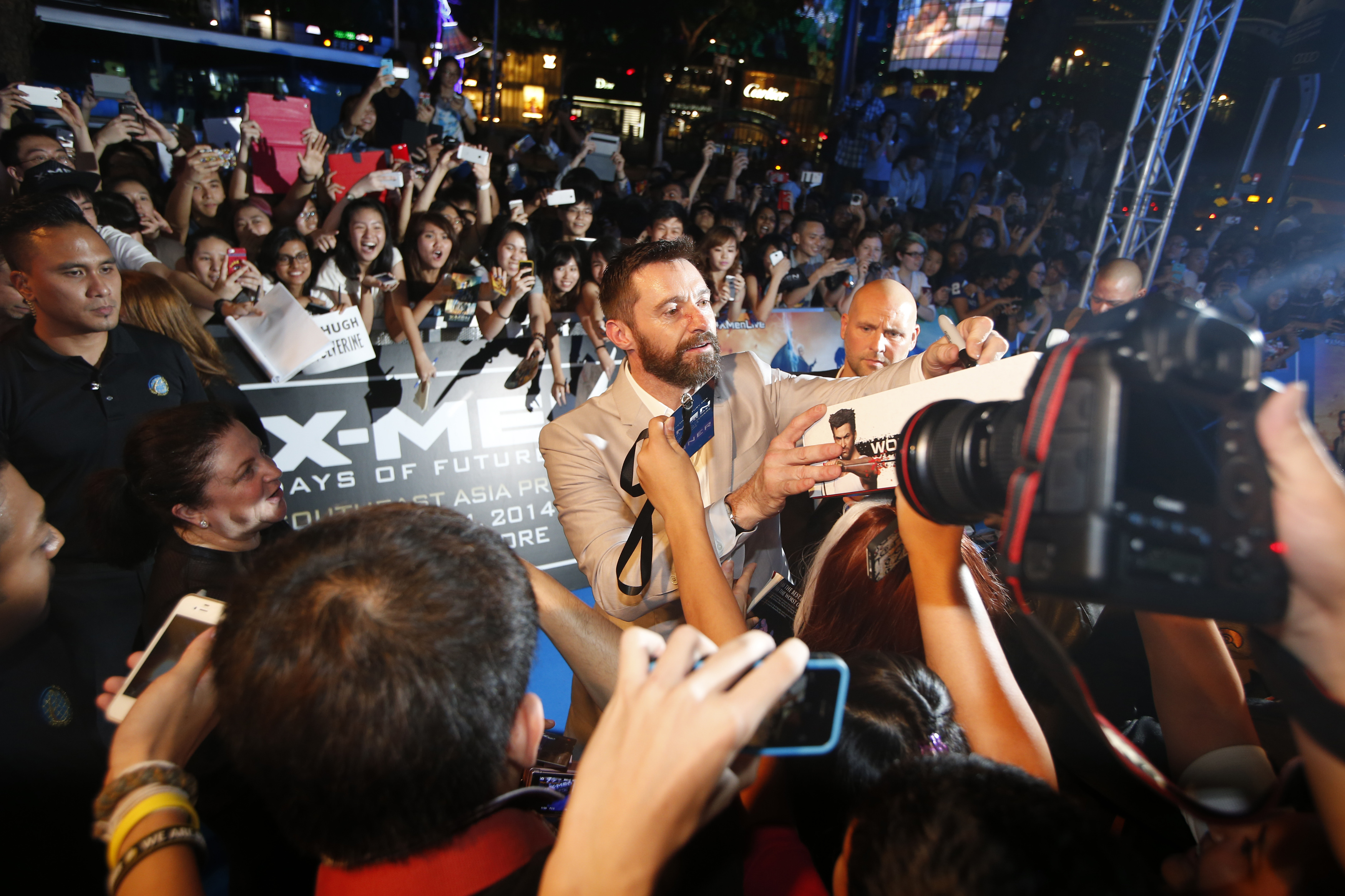 Cast member Hugh Jackman signs autographs for fans at the South East Asia premiere of X-Men: Days Of Future Past in Singapore