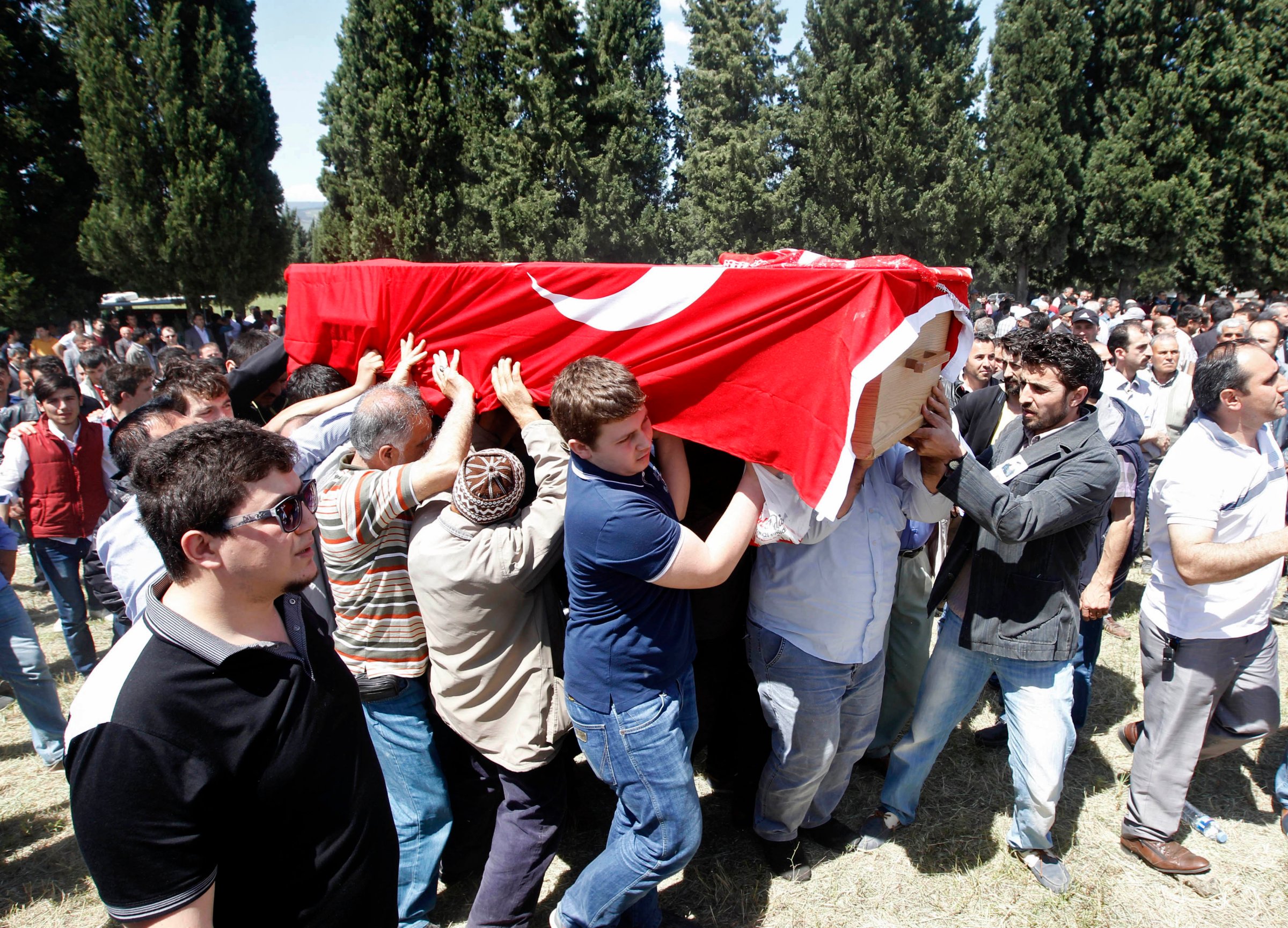 People carry the coffin of a miner who died in a fire at a coal mine, draped with a Turkish flag, during his funeral at a cemetery in Soma, a district in Turkey's western province of Manisa
