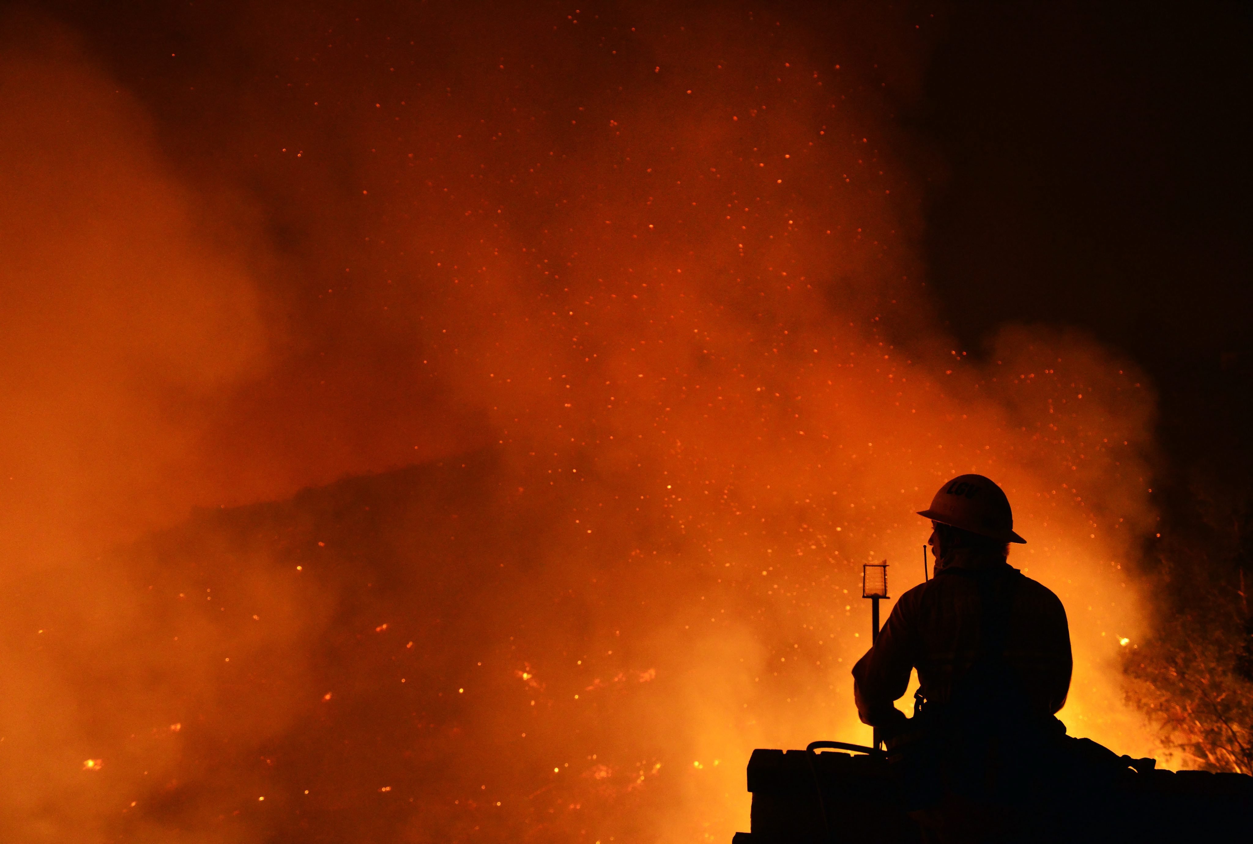 A firefighter on structure defense duty watches flames in San Marcos, San Diego county on May 14, 2014.