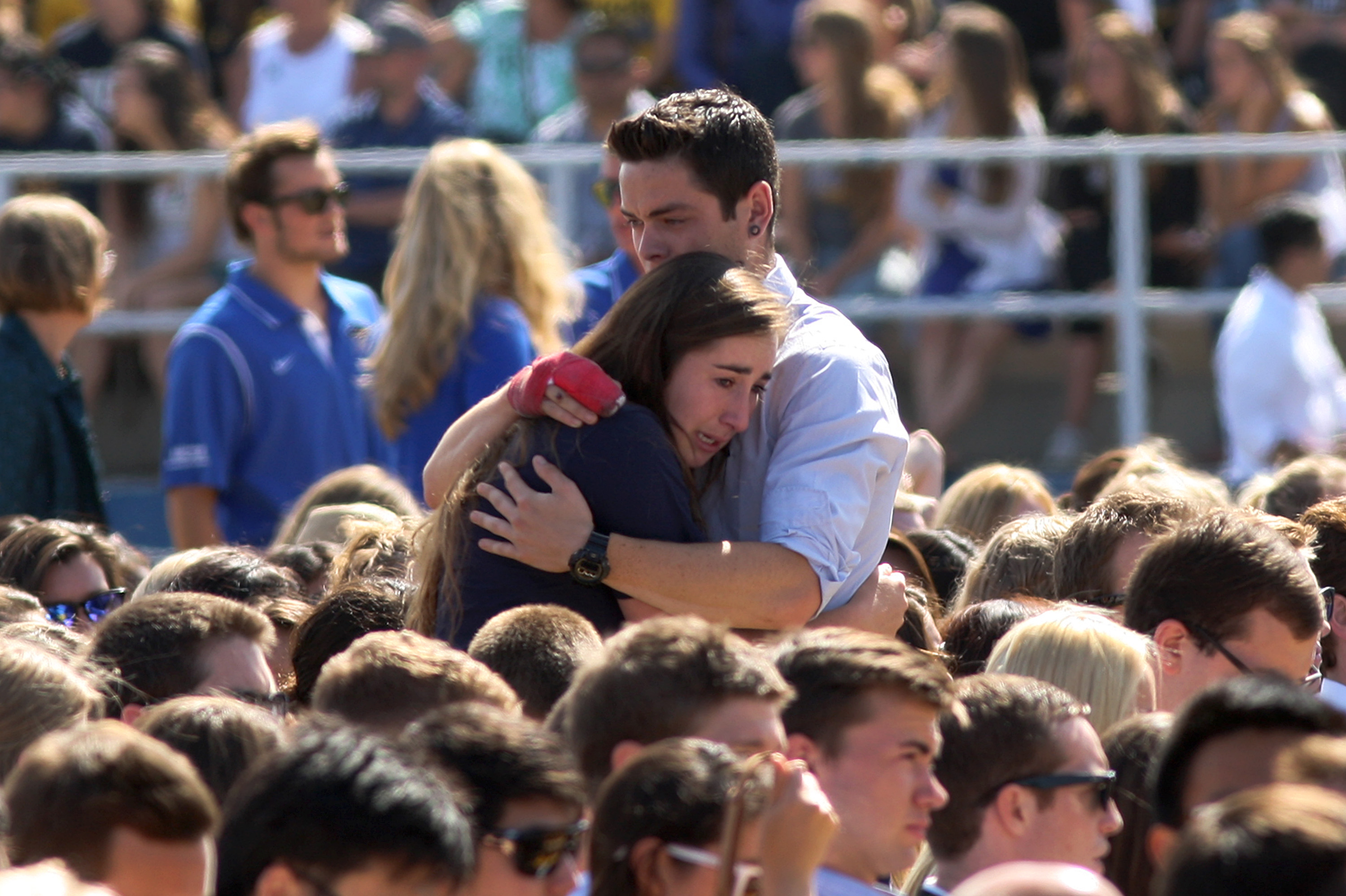 People hug at a public memorial on the Day of Mourning and Reflection for the victims of a killing spree at University of California, Santa Barbara on May 27, 2014 in Isla Vista, California. (David McNew—Getty Images)