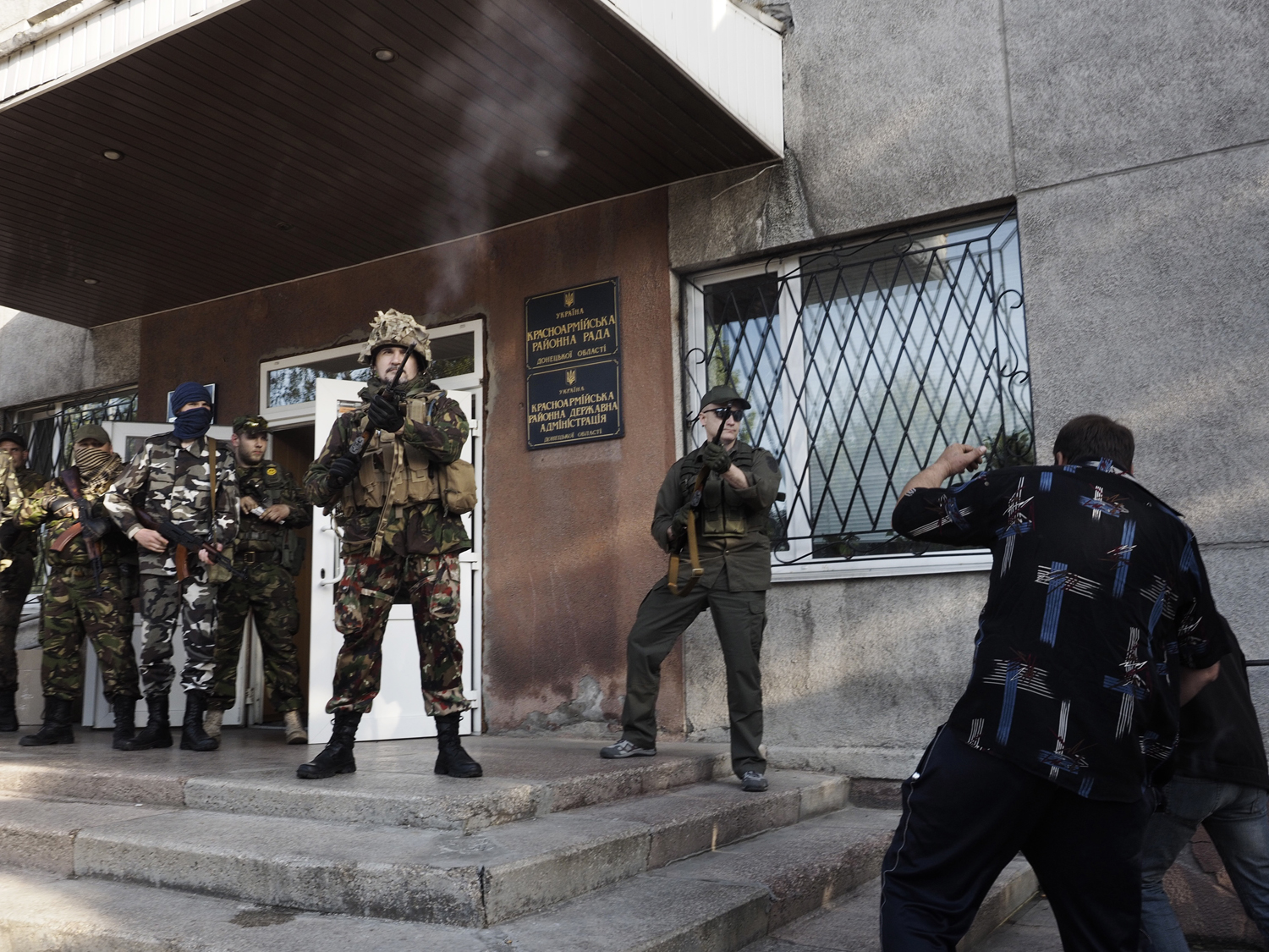 May 11, 2014. An armed guard shoots into the air while preventing civilians from voting in an illegal referendum outside a polling location in Krasnoarmeisk, eastern Ukraine.