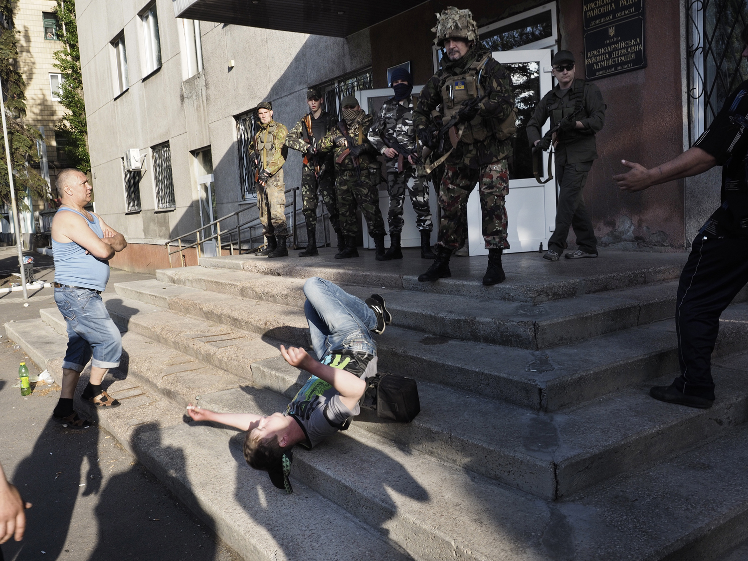 May 11, 2014. A man falls onto the stairs of the polling location, closed by Ukrainian national guards, after being hit in the head with the butt of a weapon.
