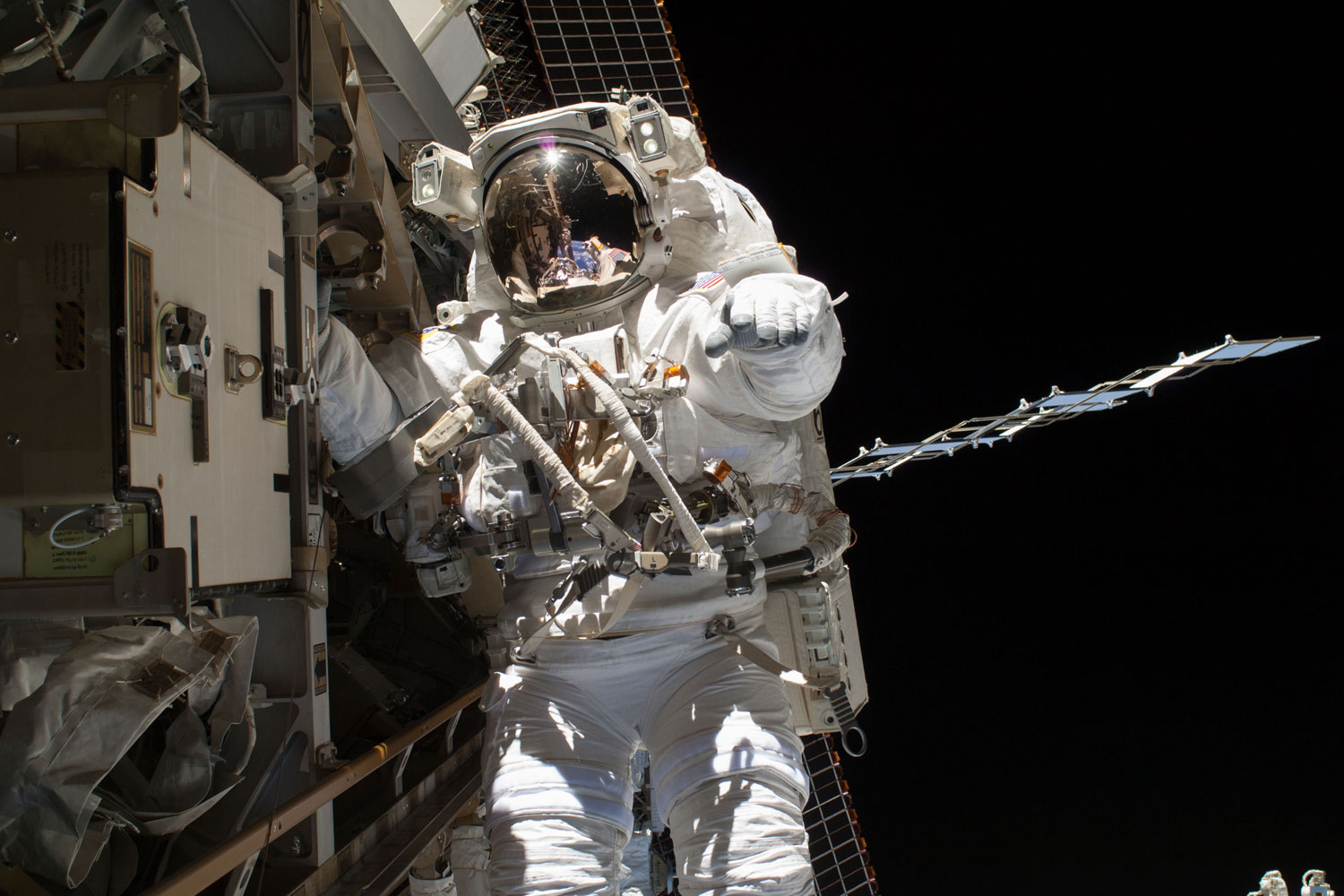 NASA astronaut Steve Swanson during a spacewalk to replace a failed backup computer relay box on the International Space Station on April 22, 2014. He was accompanied on the spacewalk by fellow Flight Engineer Rick Mastracchio of NASA, who can be seen as a tiny figure anchored several yards away reflected in Swanson's helmet visor.