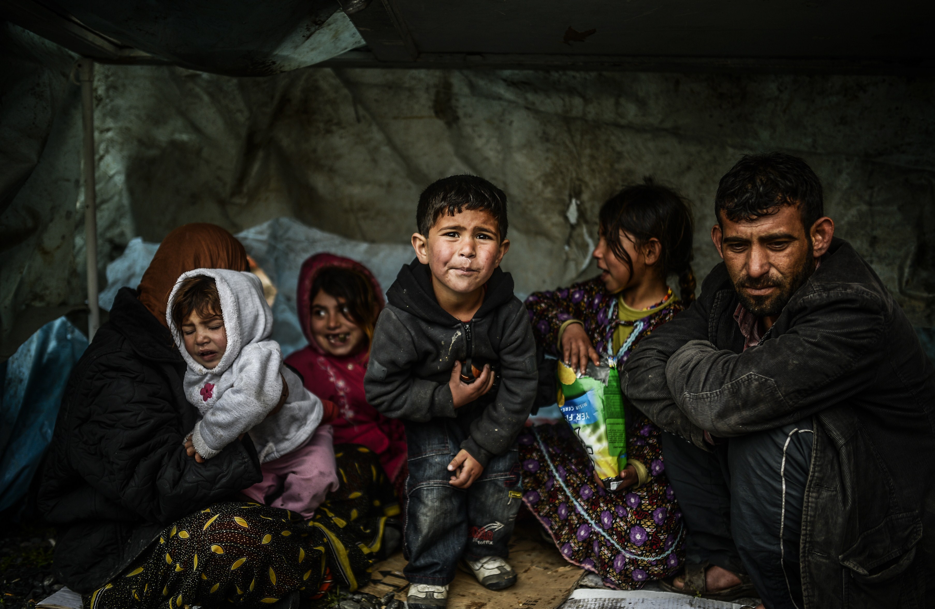 A Syrian refugee family from Aleppo stays under a shelter during a rainy day on March 8, 2014 in Uskudar, Istanbul. (Bulent Kilic—AFP/Getty Images)
