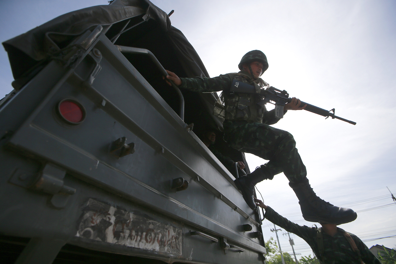 A Thai soldier jumps off a military truck after arriving at a progovernment rally site on the outskirts of Bangkok on Tuesday, May 20, 2014. (Wason Wanichakorn—AP)