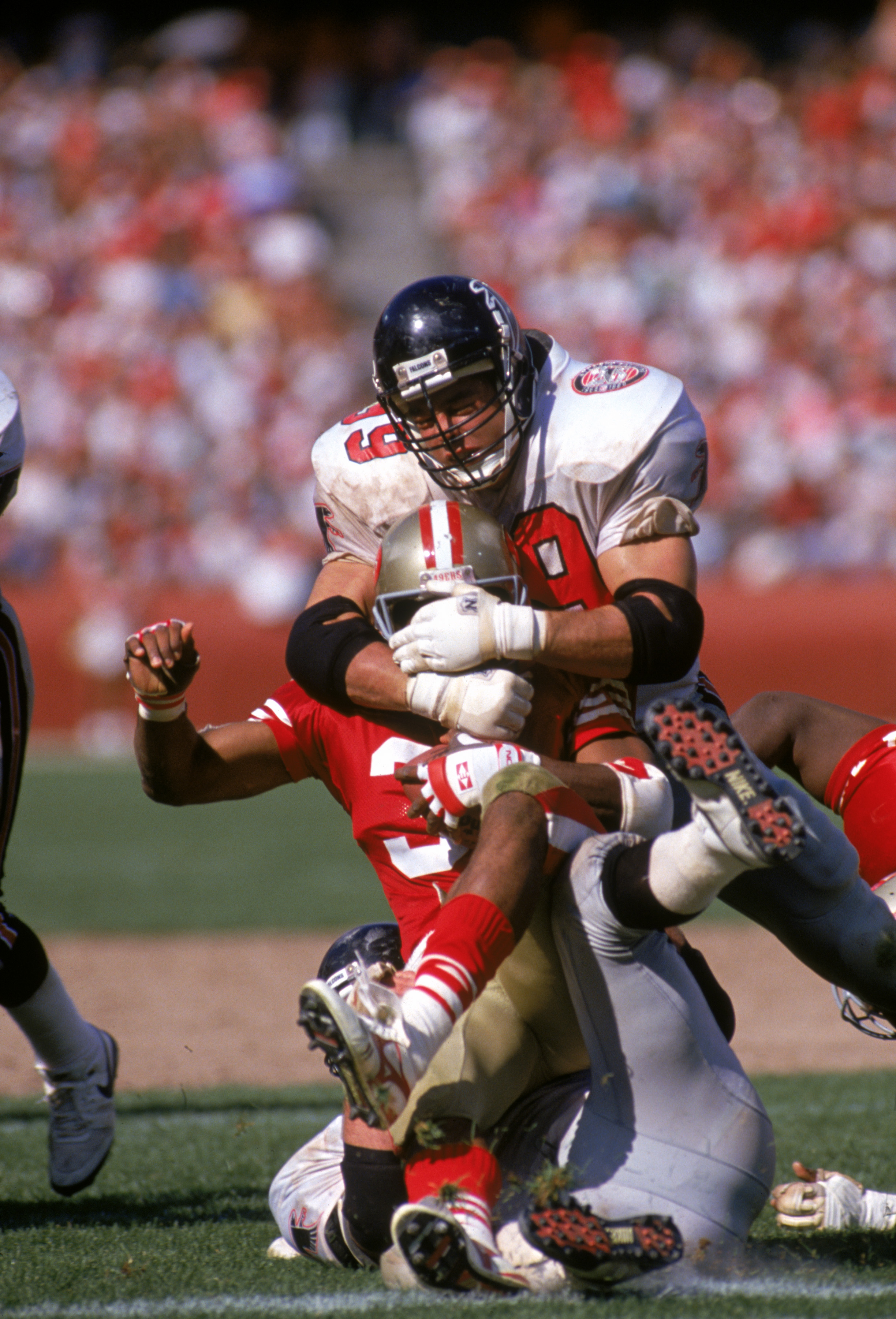 Defensive end Tim Green #99 of the Atlanta Falcons tackles running back Roger Craig #33 of the San Francisco 49ers during a game at Candlestick Park on Sept. 23, 1990 in San Francisco. (George Rose—Getty Images)