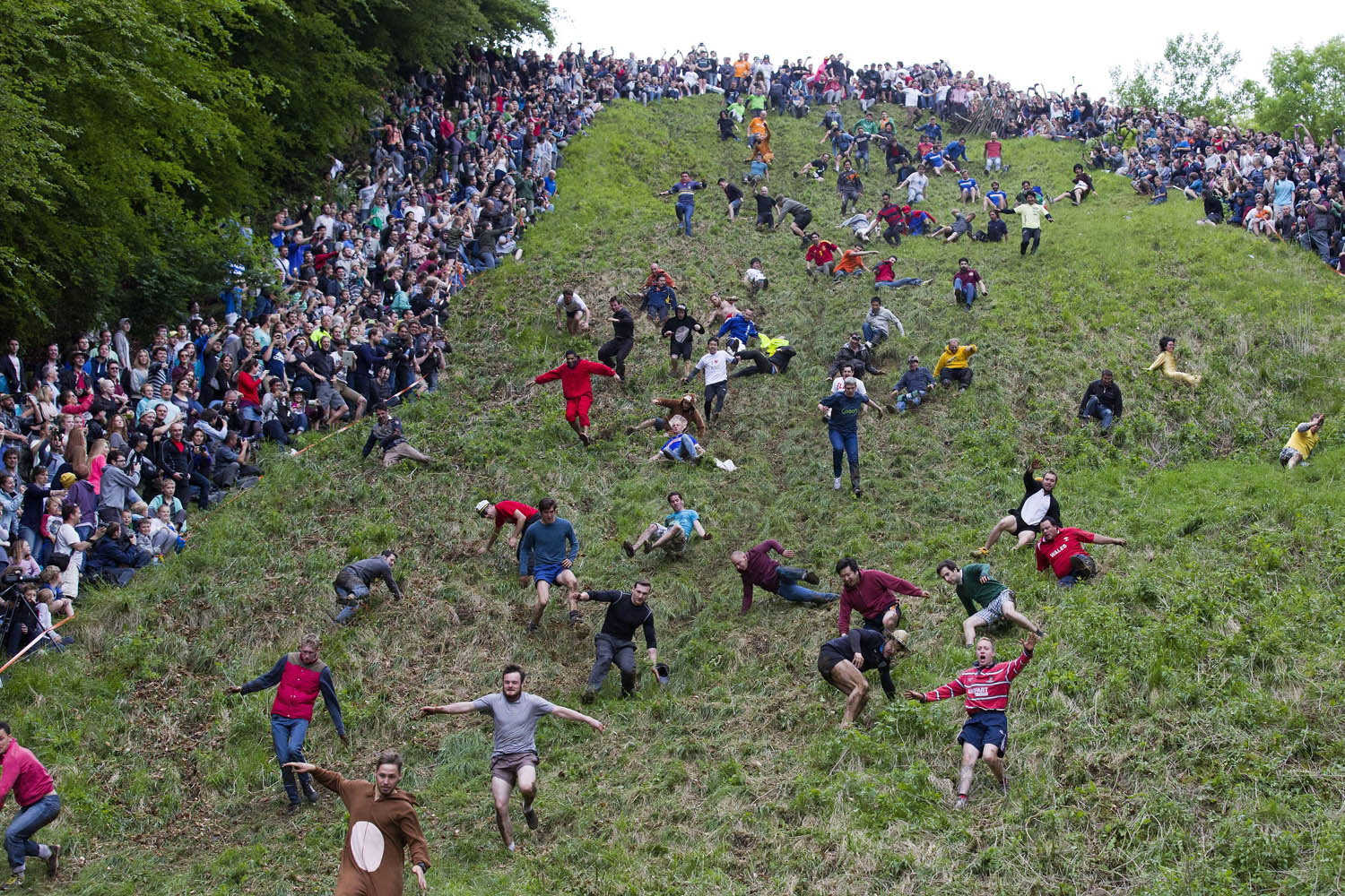 Competitors tumble down Coopers Hill in pursuit of a round Double Gloucester cheese during the annual cheese rolling and wake near the village of Brockworth near Gloucester in western England on May 26, 2014.