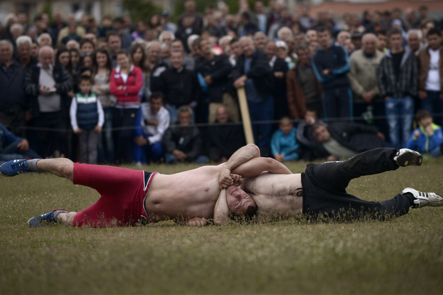 Two men compete in a wrestling tournament, part of a holiday marking the circumcisions of young boys in the village of Draginovo, some 180km south-east of Sofia, Bulgaria, on May 4, 2014.