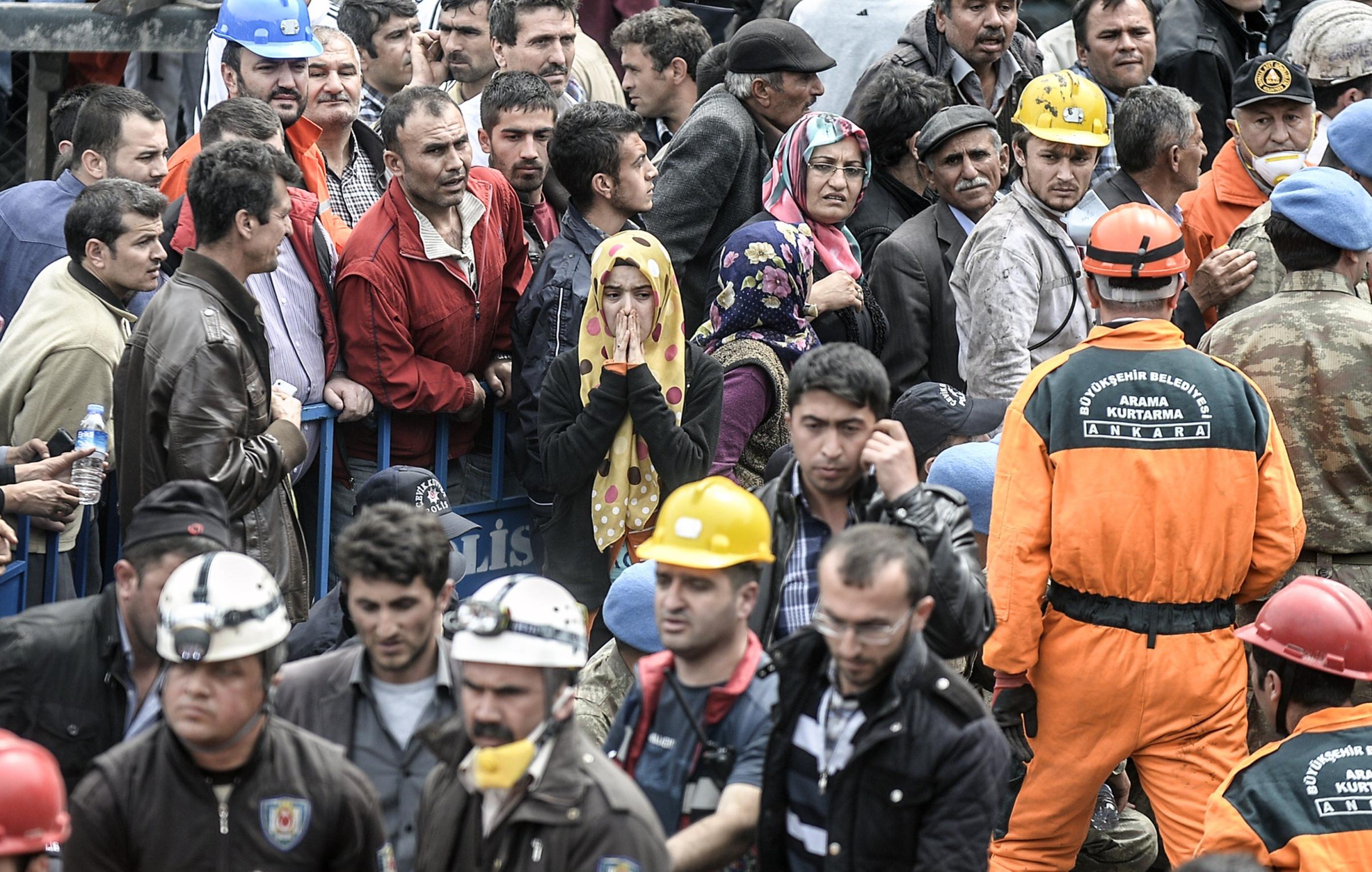 People gather, searching for their relatives, as rescuers carry out bodies of dead miners on May 14, 2014 after an explosion and fire in a coal mine in the western Turkish province of Manisa.