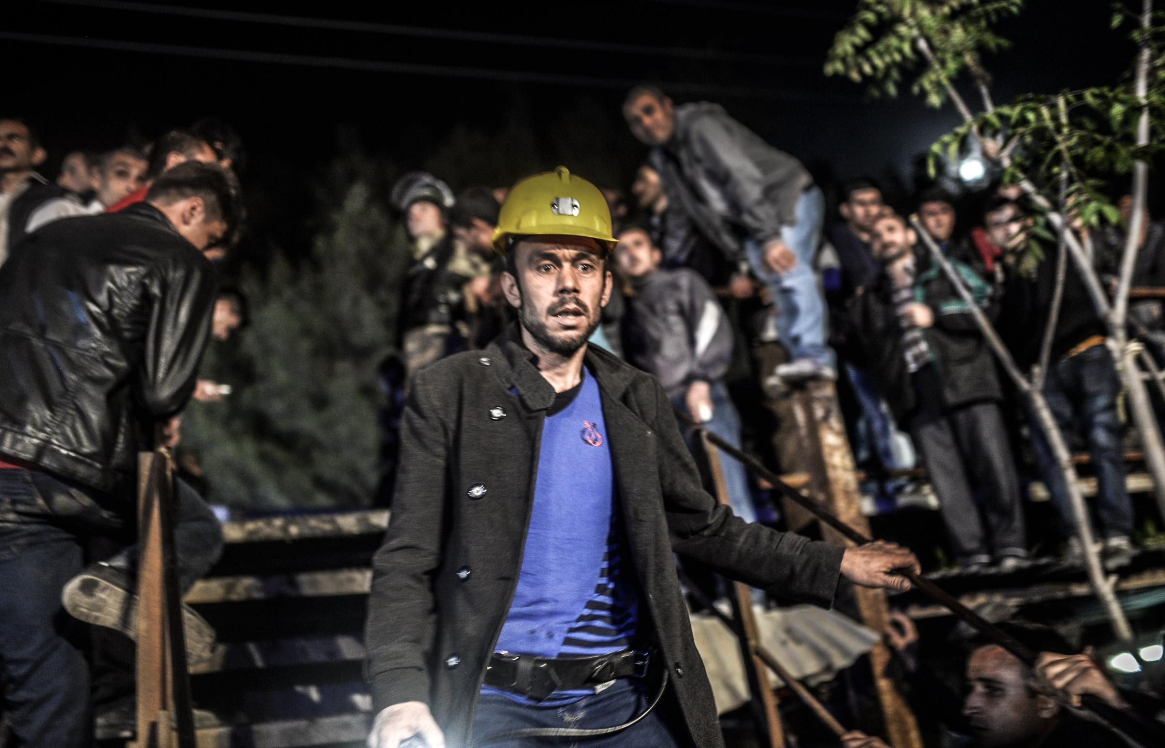 Miners wait at the gate of a mine after an explosion in Manisa on May 13, 2014.