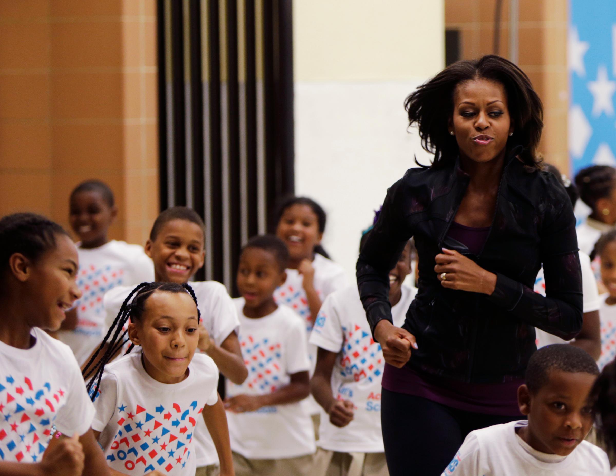 U.S. First Lady Obama jogs with children at a back-to-school event in Washington