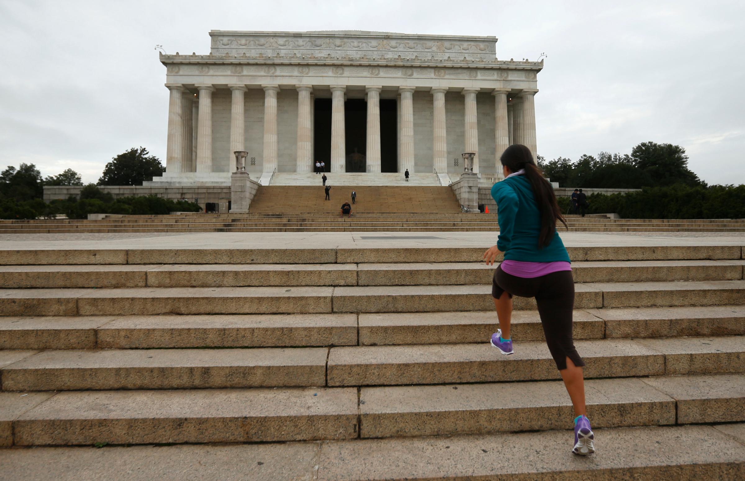 Natali Segovia, a tourist from Arizona, runs up the steps of the Lincoln Memorial as it is re-opened to the public in Washington