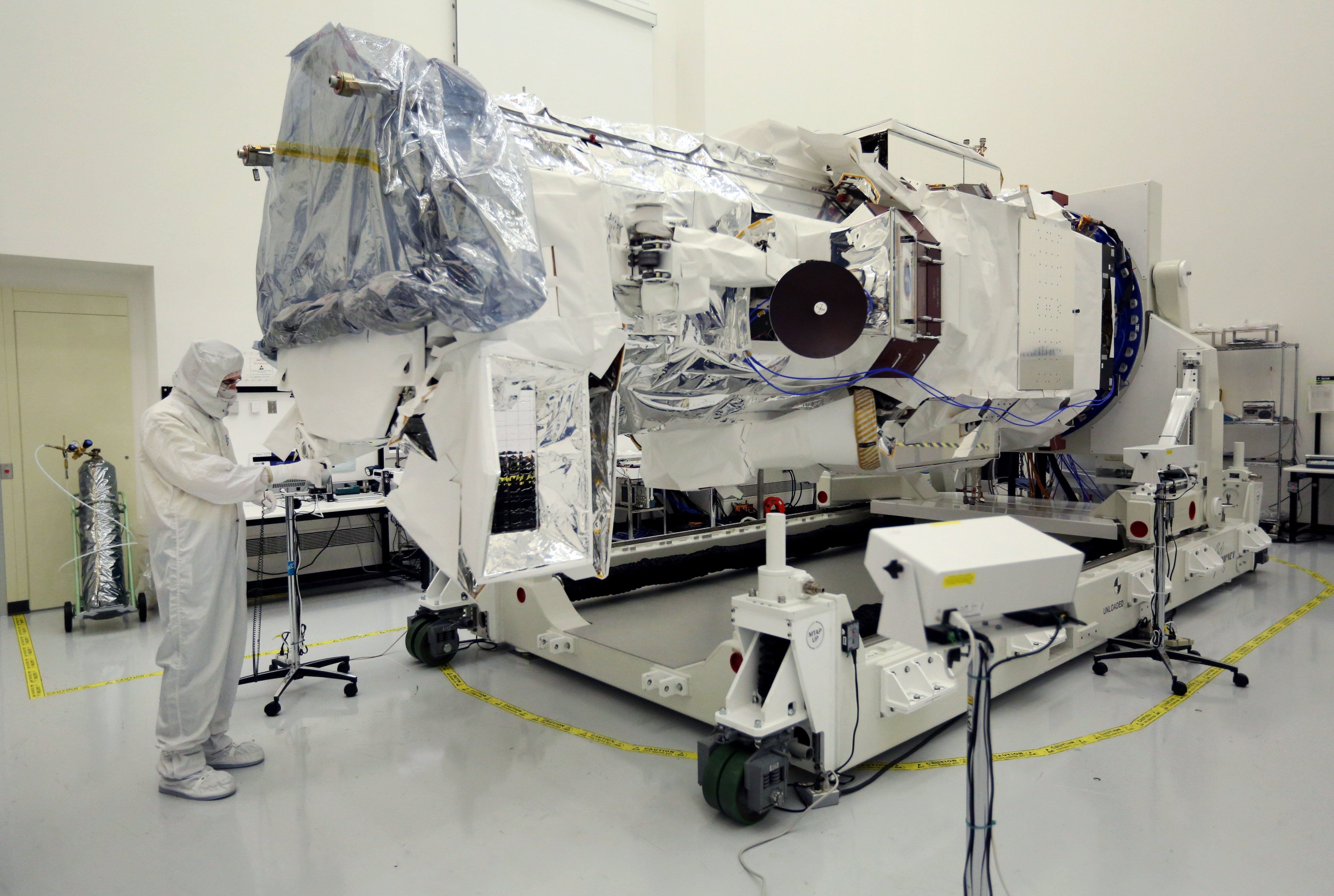 A technician wearing a clean suit runs tests on WorldView-3, a new high-resolution imaging satellite owned by commercial satellite company DigitalGlobe, at Ball Aerospace in Boulder, Colo., on Tuesday, May 13, 2014. 