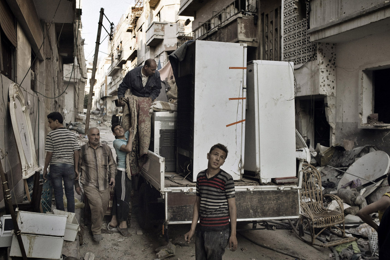 Former residents of the Qabaris neighborhood of Homs salvage what they could from their former homes. May 12, 2014.