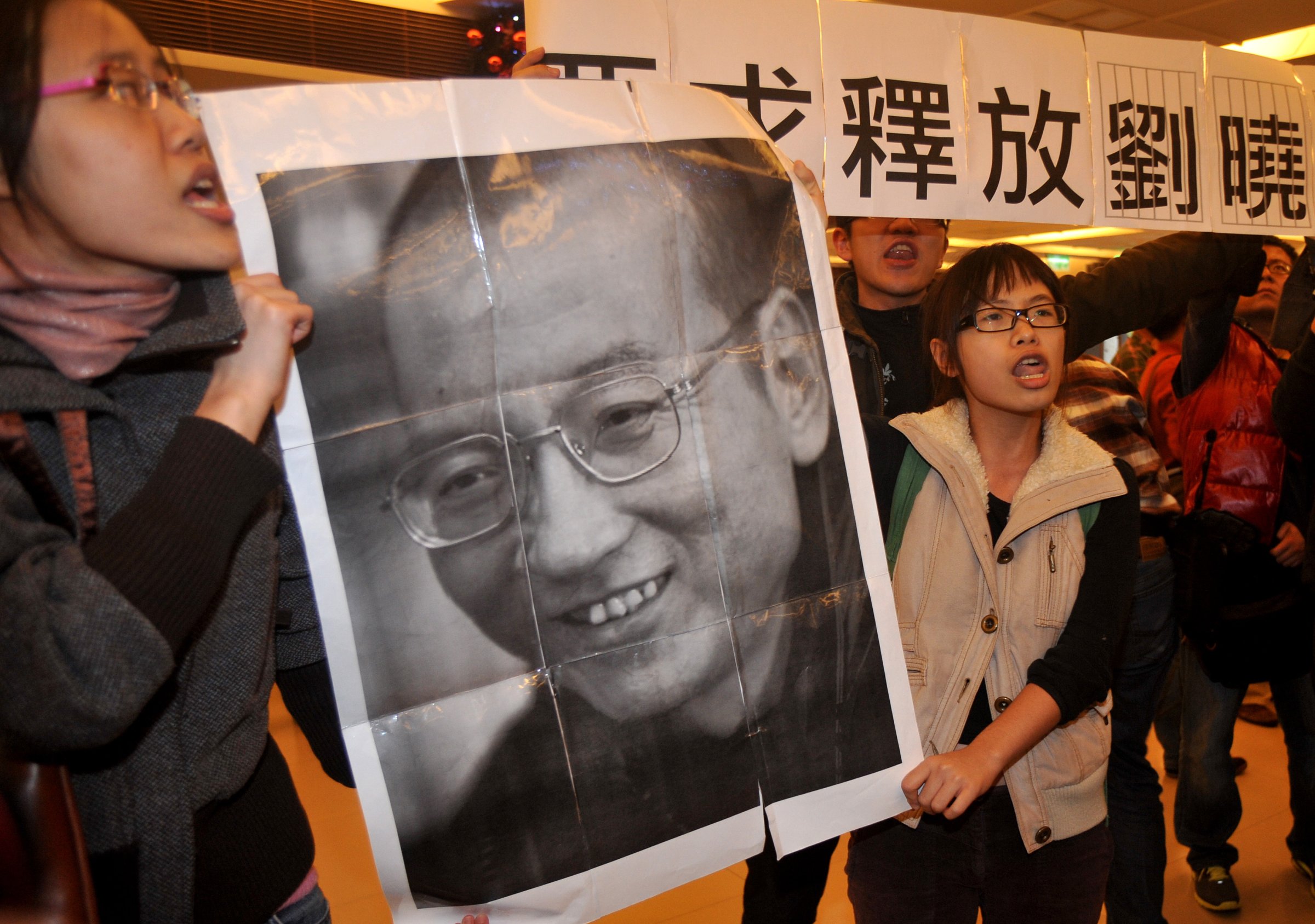 Demonstrators hold a portrait of China's