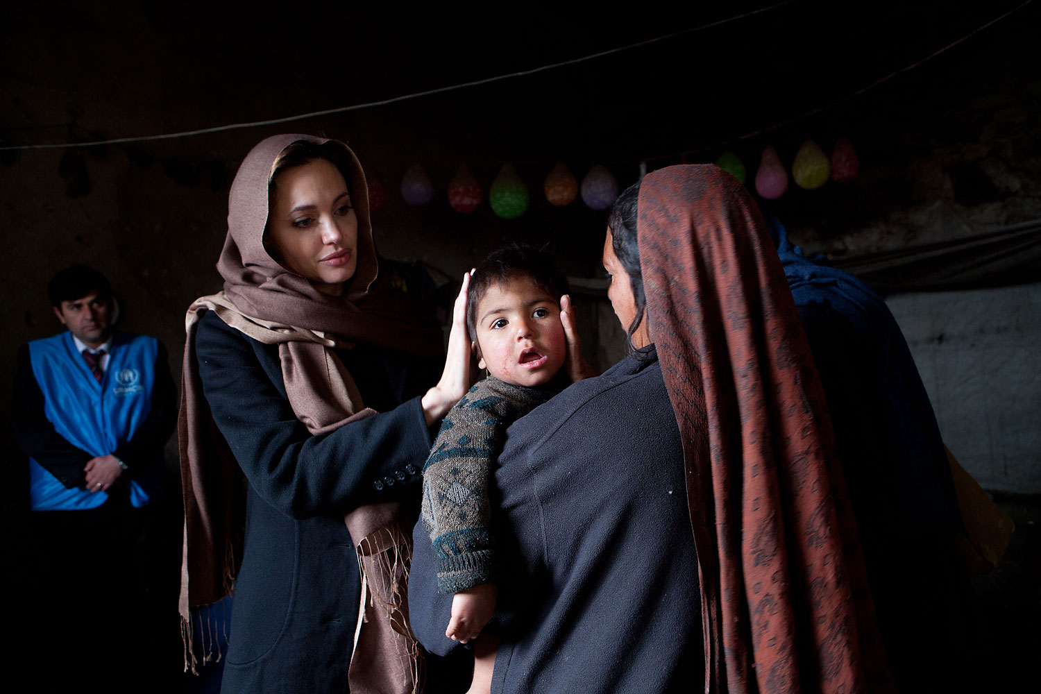Angelina Jolie, meets with Khanum Gul, 35, a mother of 8 and her youngest son, Samir at their makeshift home at Tamil Mill Bus site in Kabul city, Afghanistan in Feb. 2011.