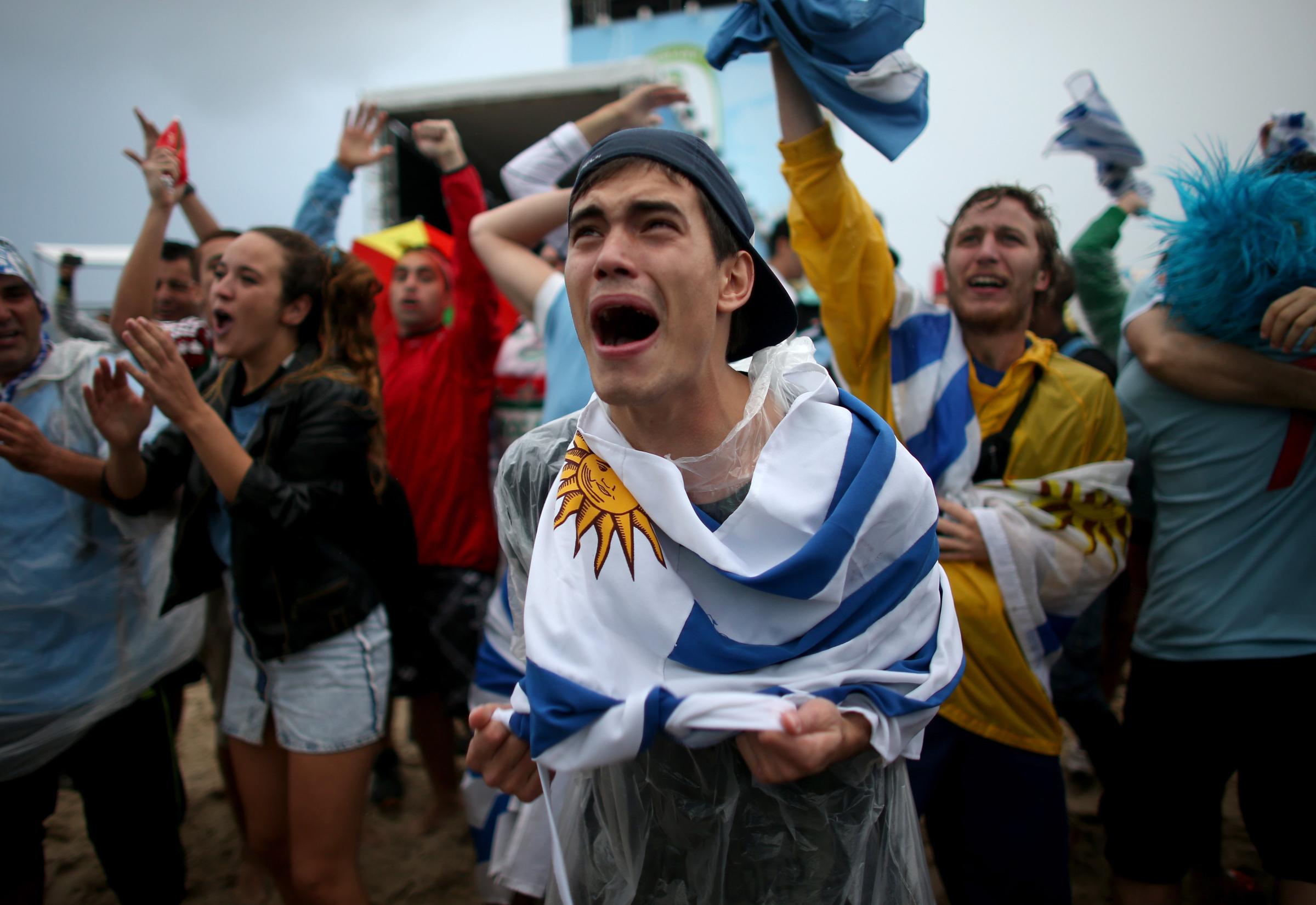 Uruguay fans celebrate as Uruguay scores their first goal against England as seen on the screen set up at Word Cup FIFA Fan Fest on Copacabana beach on June 19, 2014 in Rio de Janeiro.