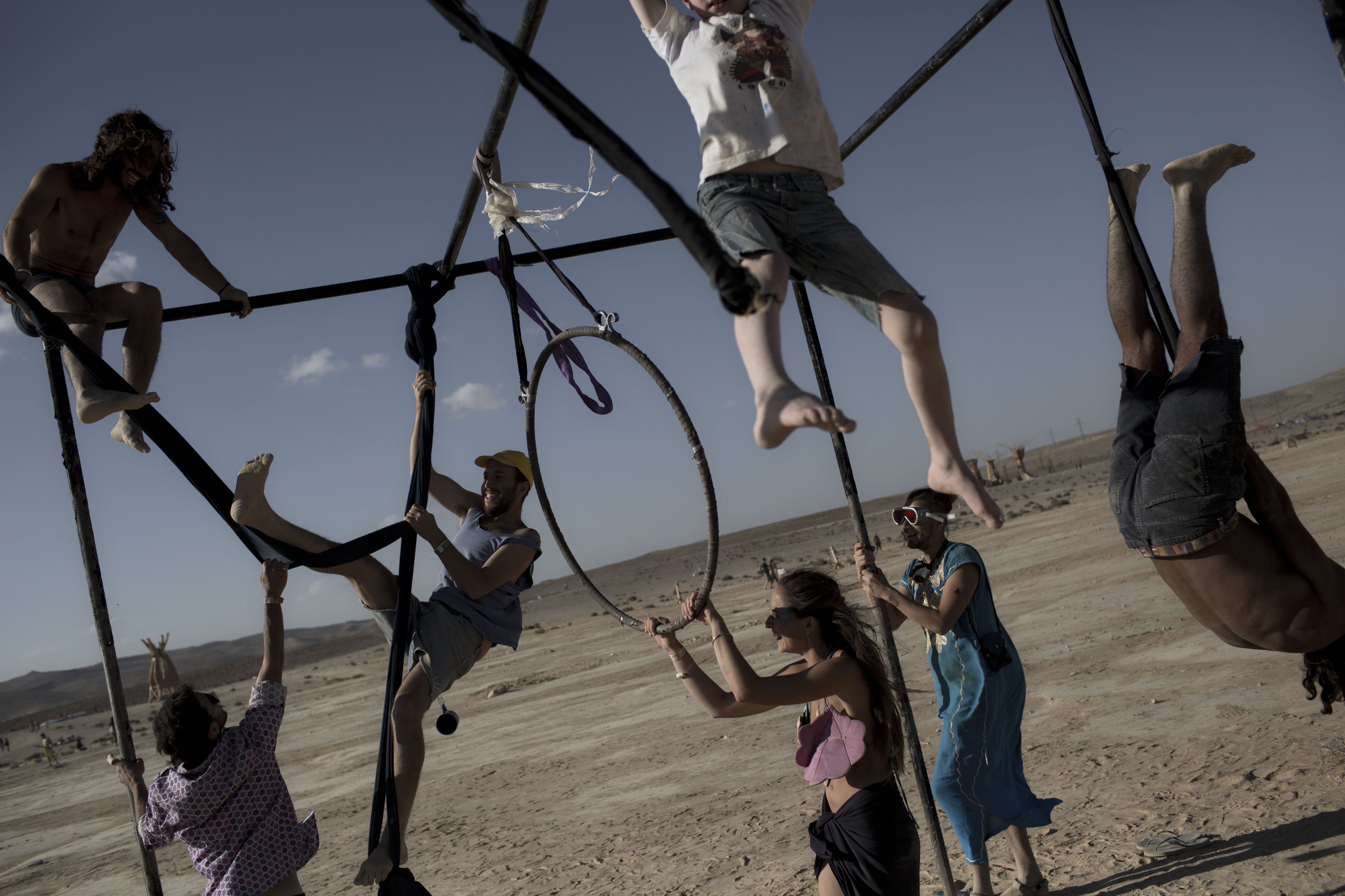 Israeli's climb on one of the art installation at Israel's first Midburn festival in the Negev Desert, Israel on June 6, 2014.