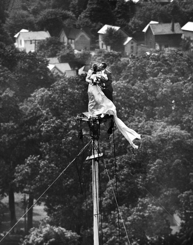 Engaged couple Marshall and Yolanda Jacobs kiss atop a flagpole, Coshocton, Ohio, June 1946, prior to their wedding.