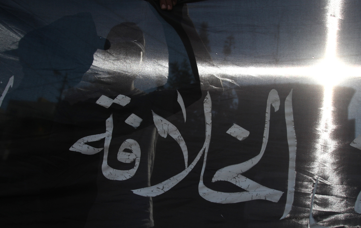 Silhouetted behind the Arabic word "cali