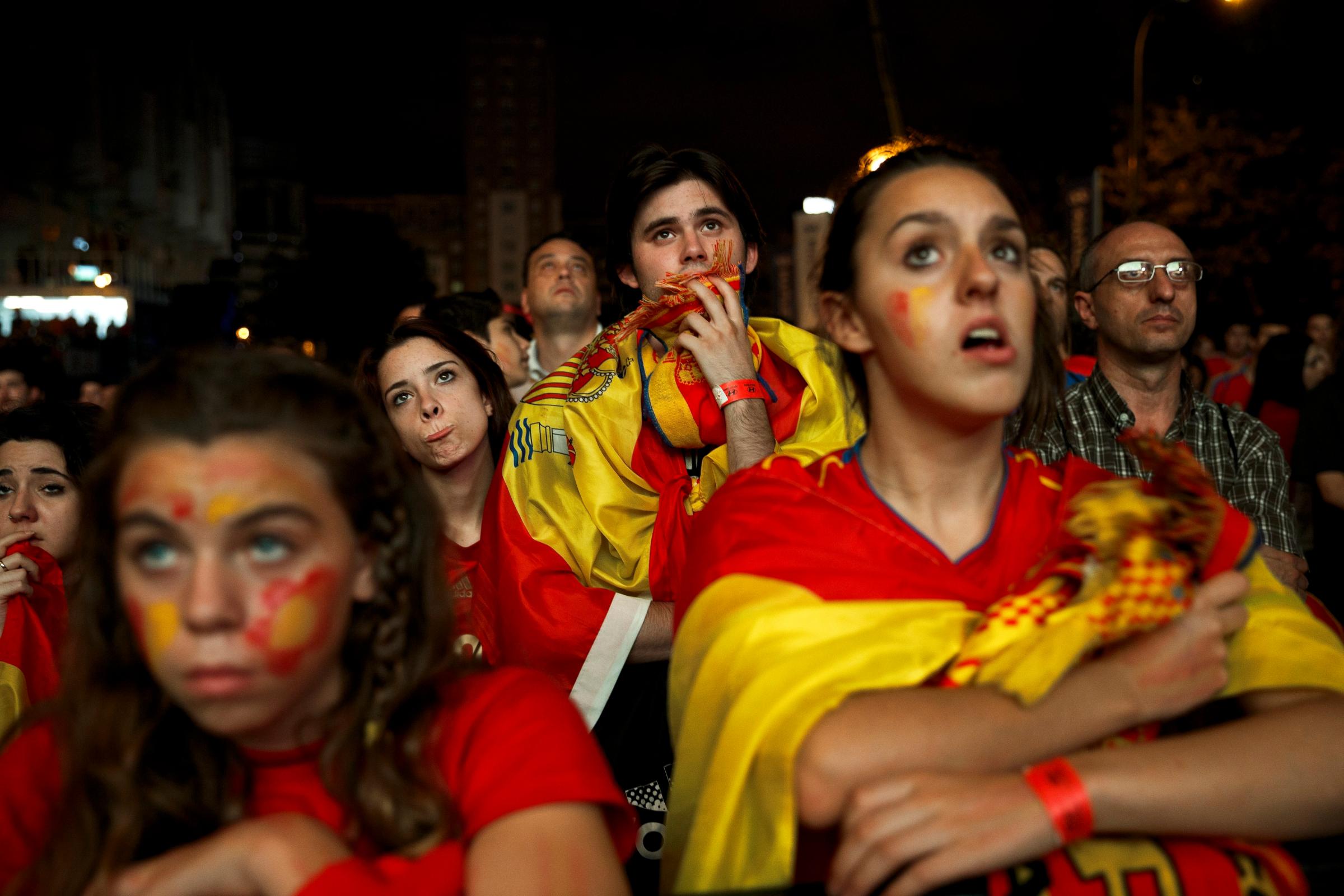 Spanish soccer fans react while watching the soccer game between Spain and the Netherlands in Madrid on June 13, 2014.