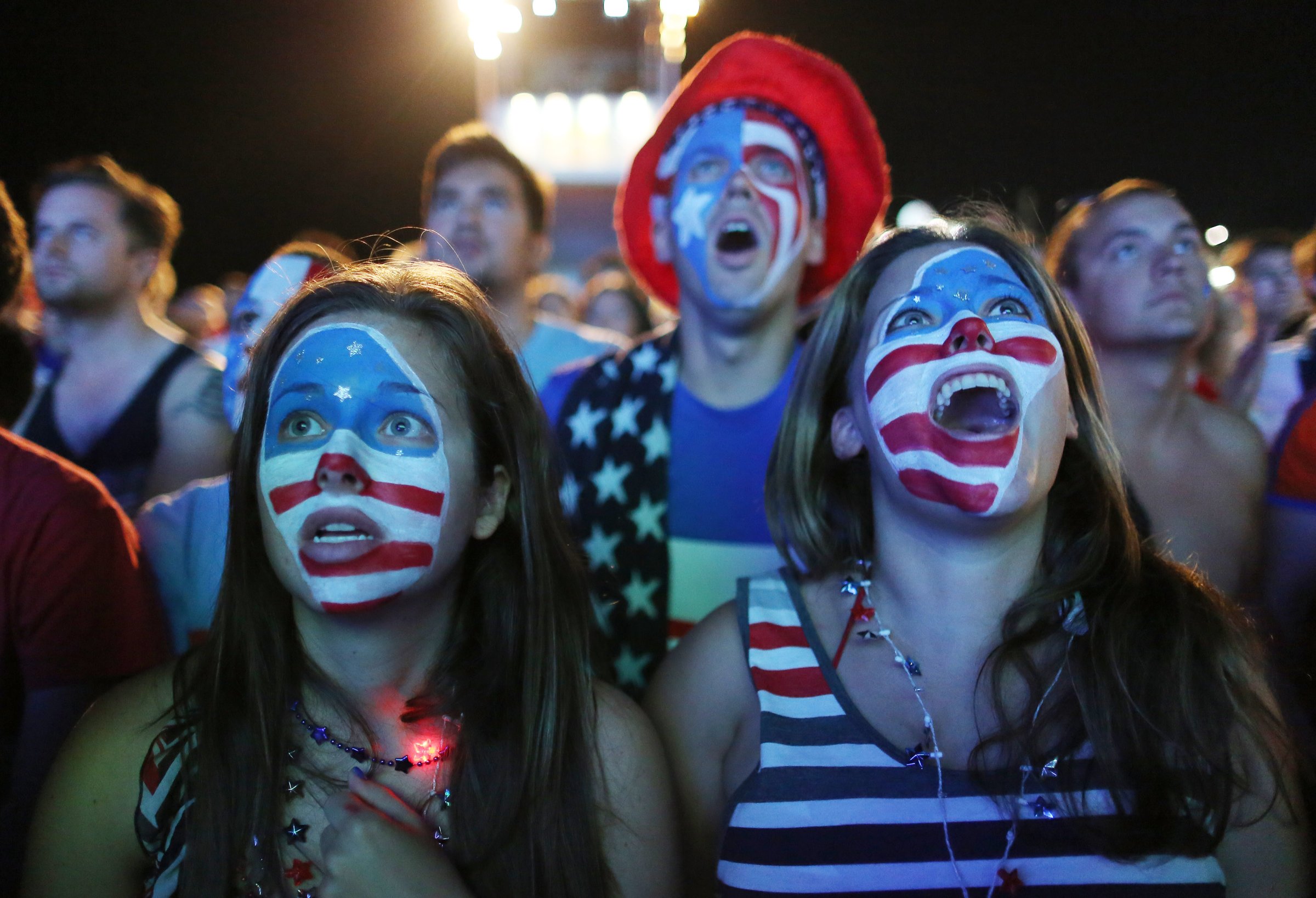 Fans with their faces painted with the U.S. national soccer team's colors, watch a live telecast of the group G World Cup match between United States and Portugal, inside the FIFA Fan Fest area on Copacabana beach, in Rio de Janeiro on June 22, 2014.