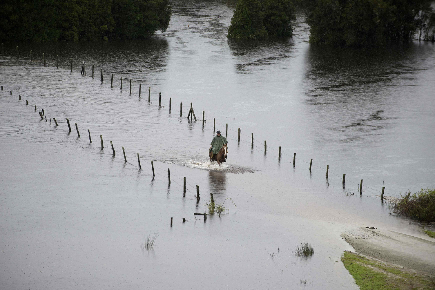 A resident rides his horse along a a flooded road near Puerto Varas city south of Santiago