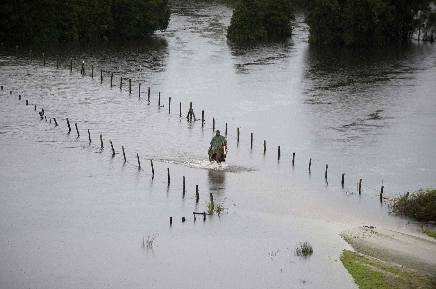 A resident rides his horse along a a flooded road near Puerto Varas city south of Santiago