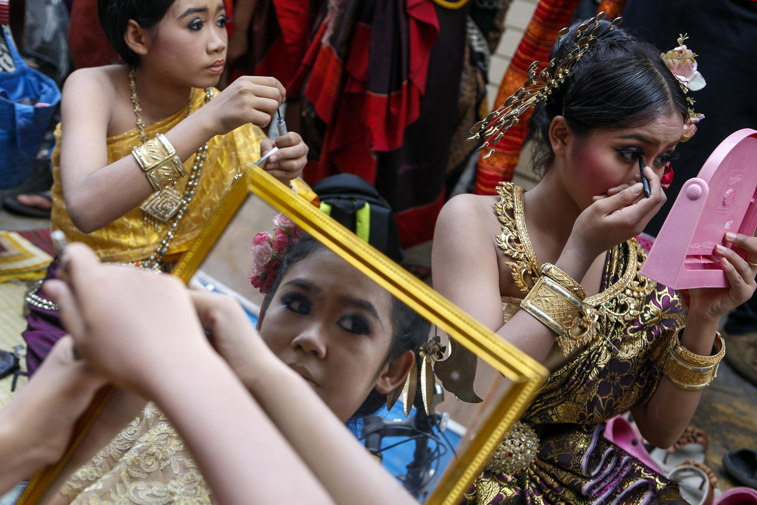 Dancers get their make up done backstage before their show at the Victory Monument during a military event in Bangkok