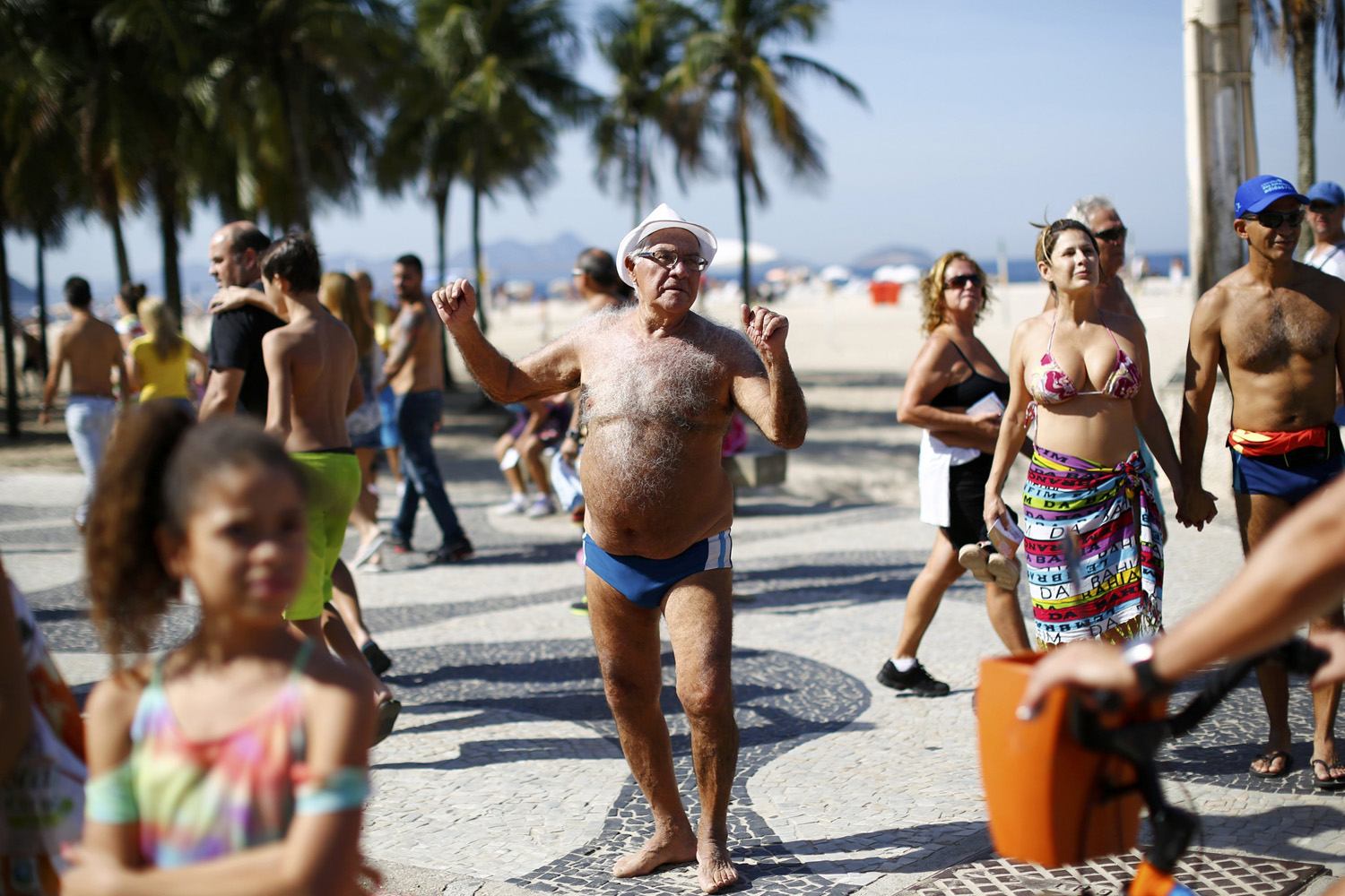 A man dances during a parade with puppets depicting soccer players at Copabana beach in Rio de Janeiro